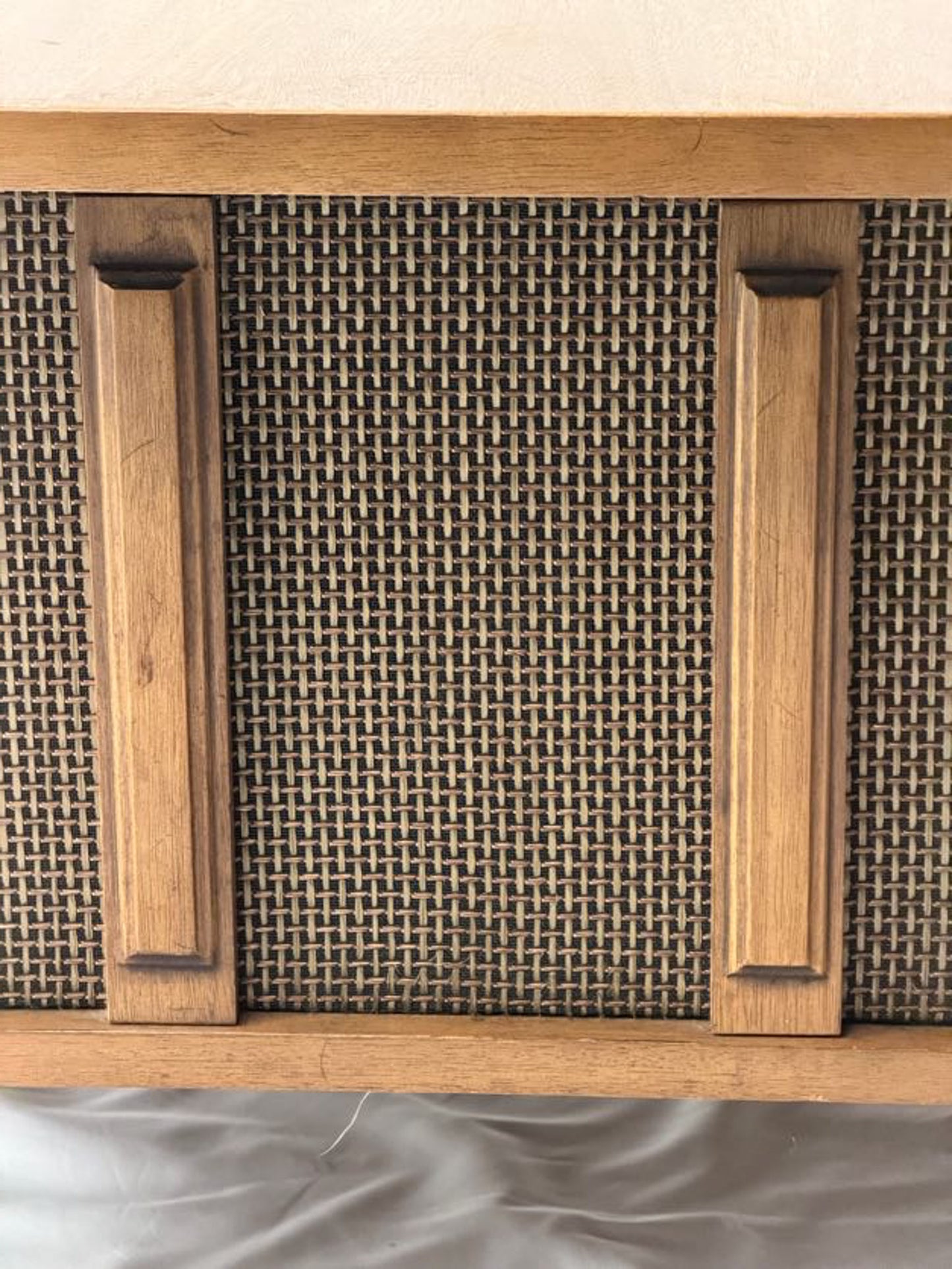 Wooden cabinet with woven design on a neutral background
