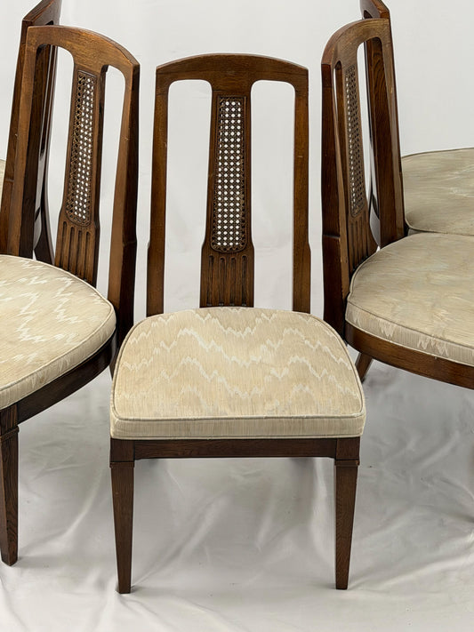 Set of six wooden chairs with beige cushioned seats on a white background