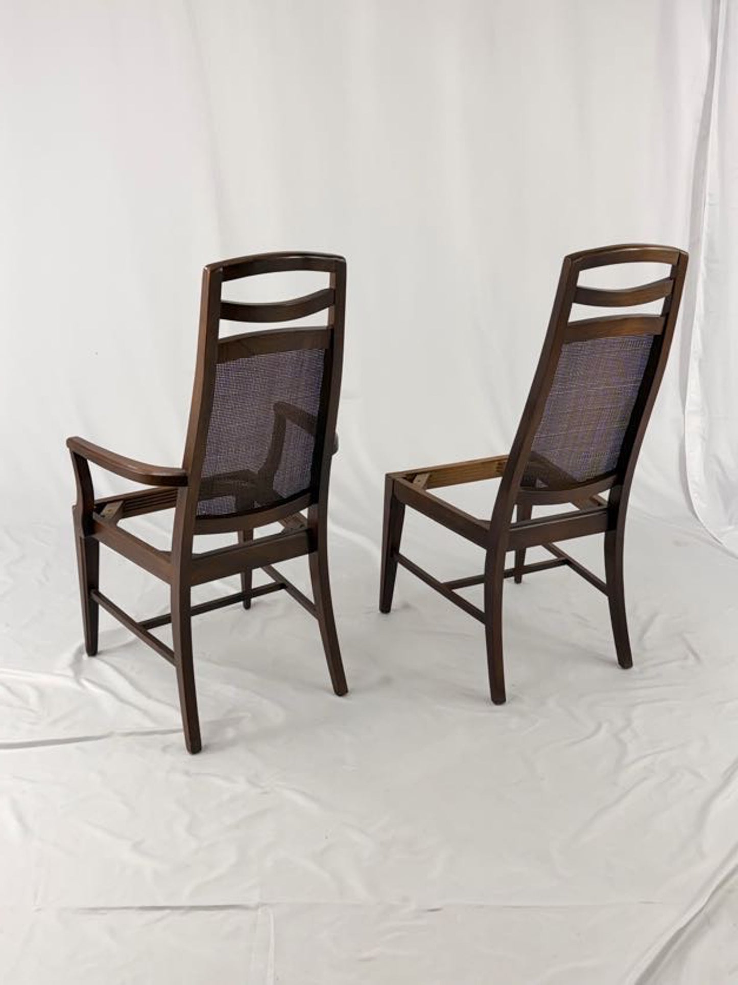 Two wooden chairs with woven backrests on a white background