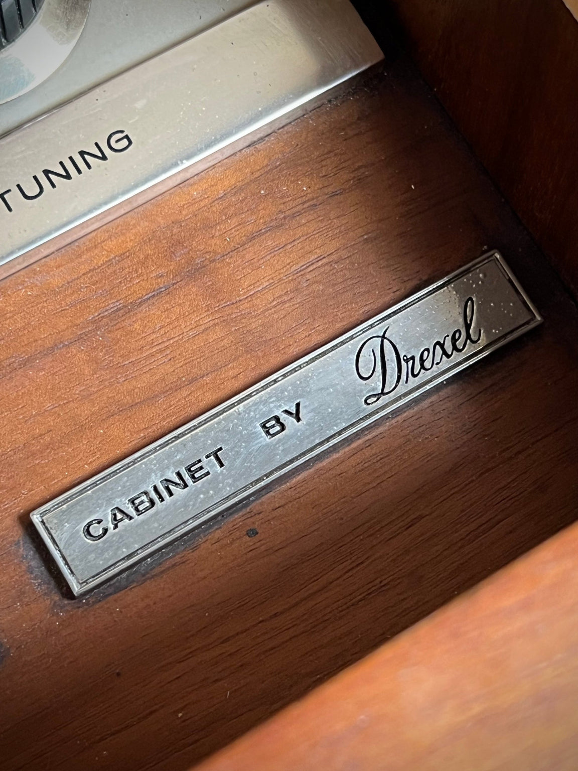 Metal label on a wooden surface with 'Drexl' branding
