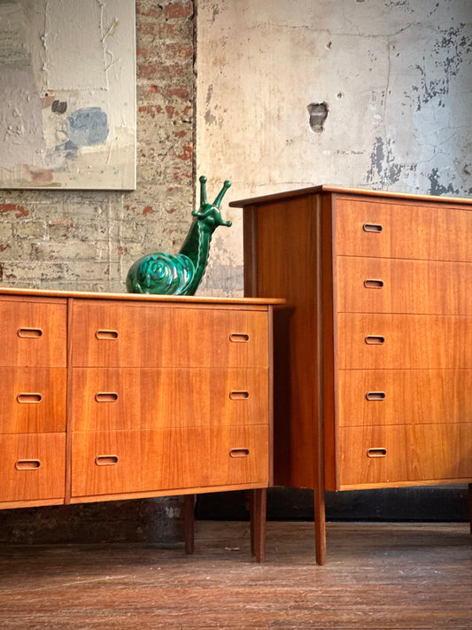A vintage teak bedroom set with highboy and lowboy furniture, featuring Exo-legs, displayed in a brick wall background.
