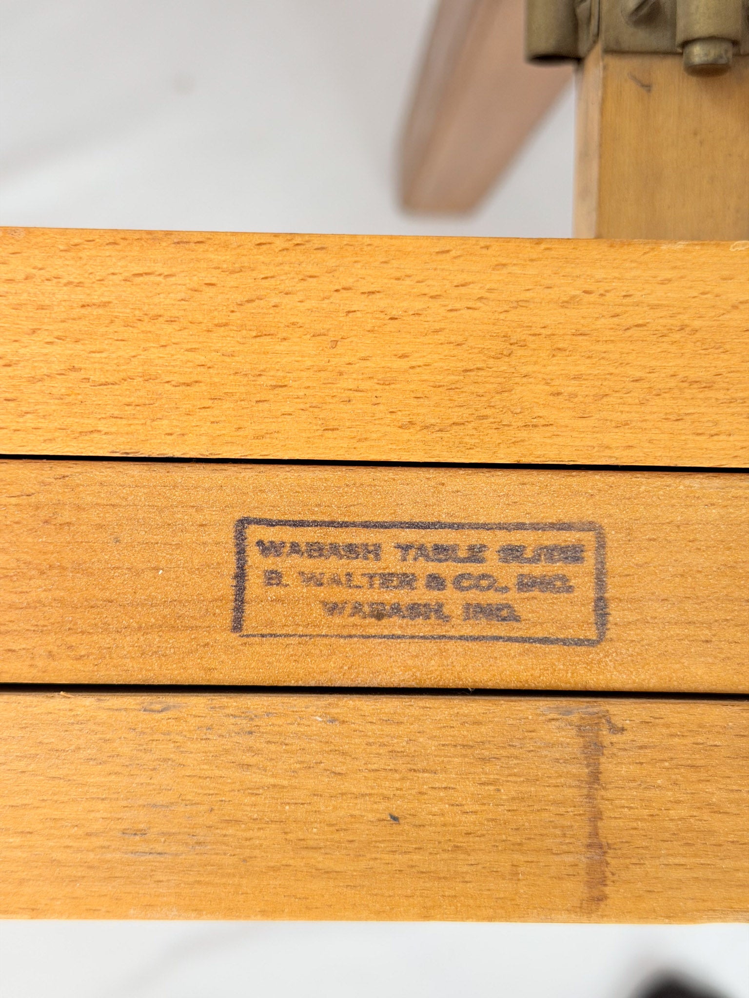 Wooden dining table with makers mark  on a white background