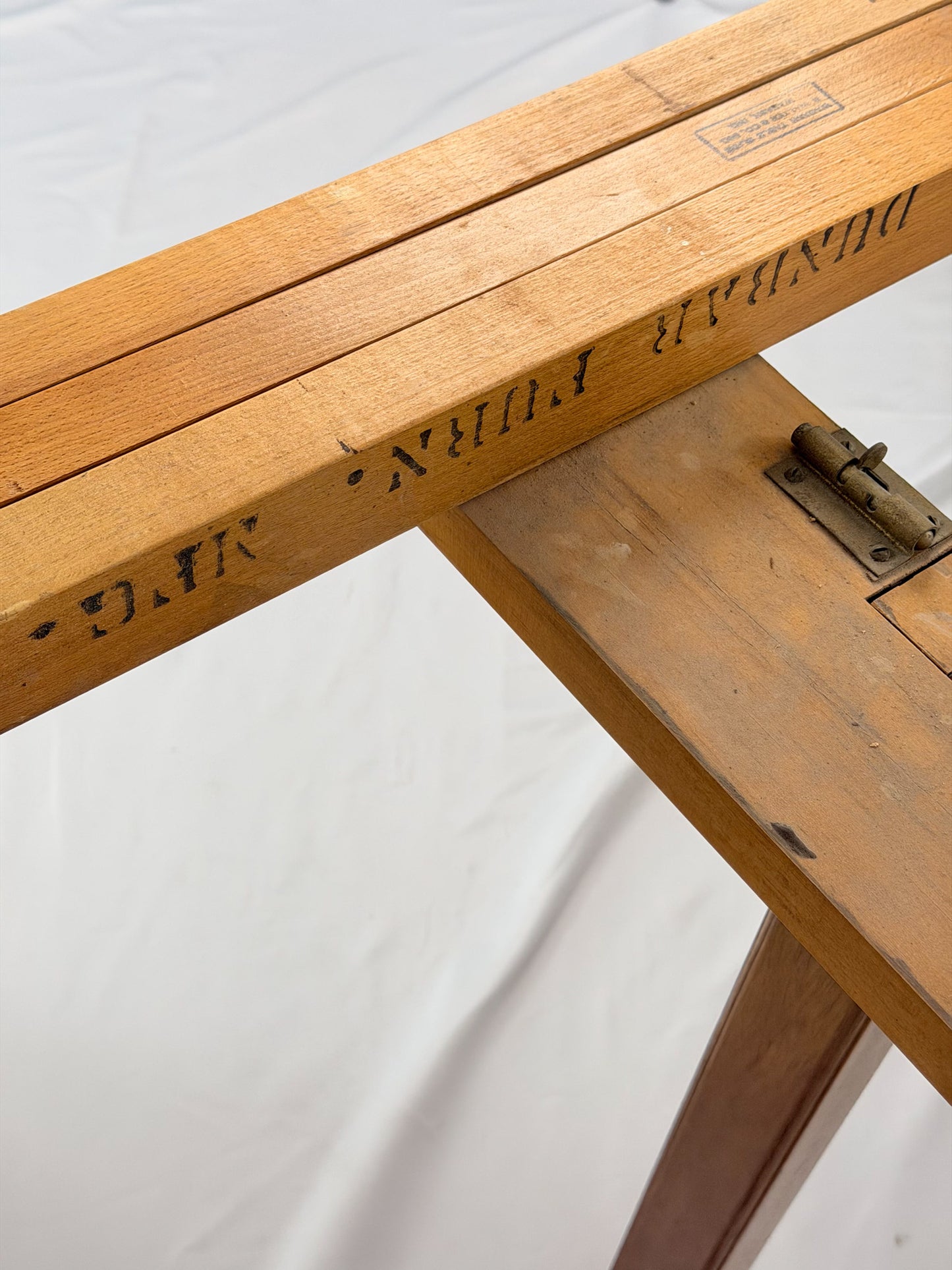 Wooden dining table with makers mark  on a white background