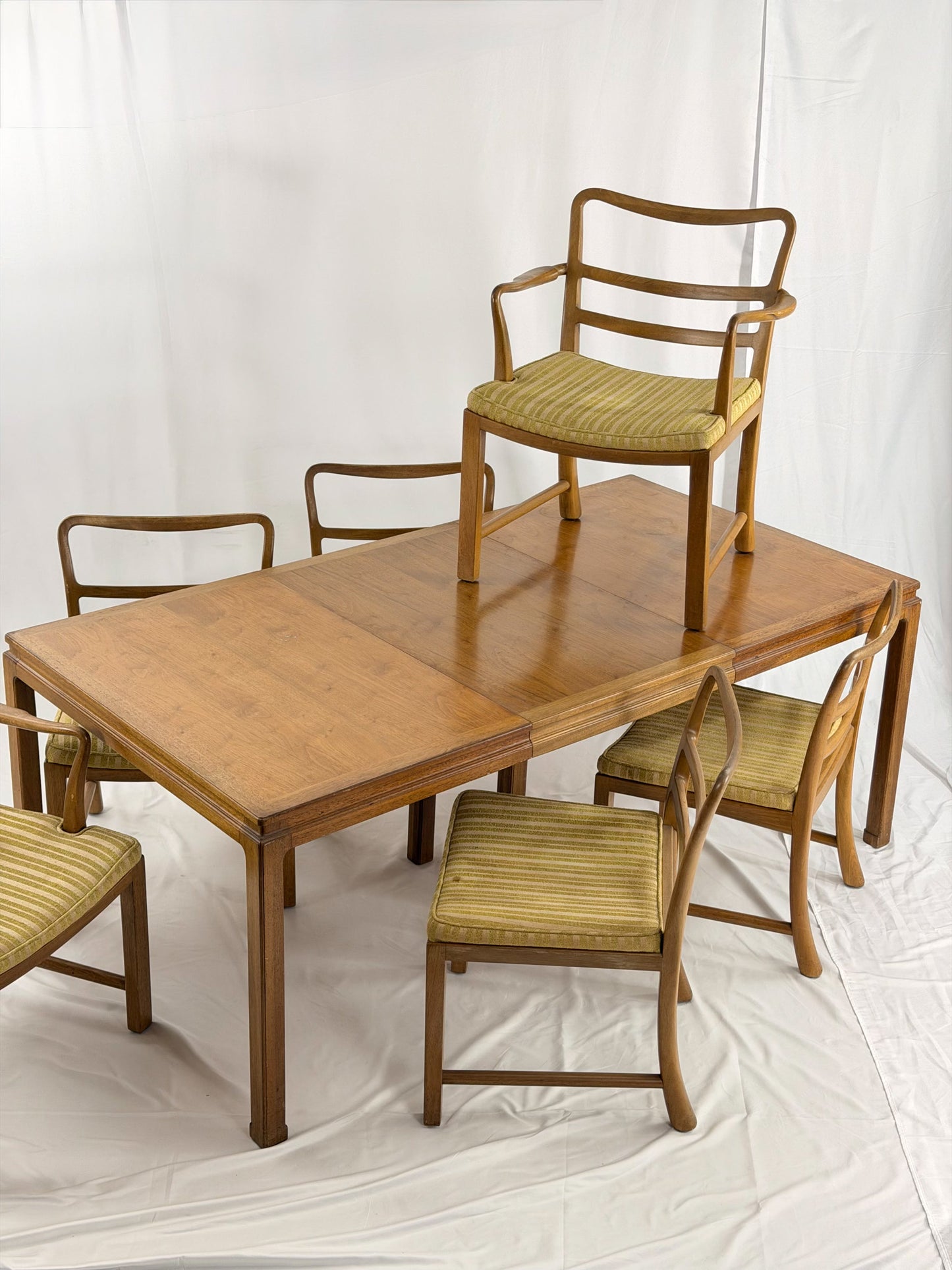 Wooden dining table with matching chairs on a white background