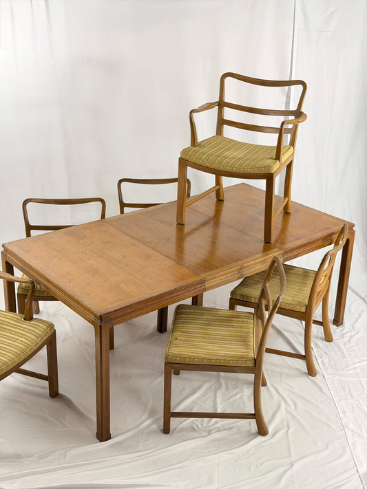 Wooden dining table with matching chairs on a white background
