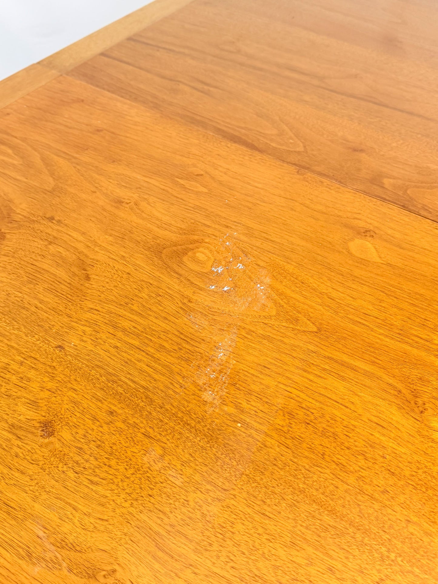 Close-up of a wooden dining tabletop with scratch marks