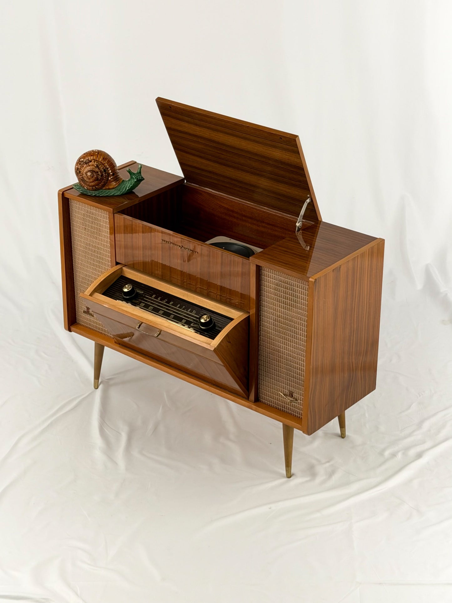 Vintage record player with a turntable and control panel on a wooden surface.