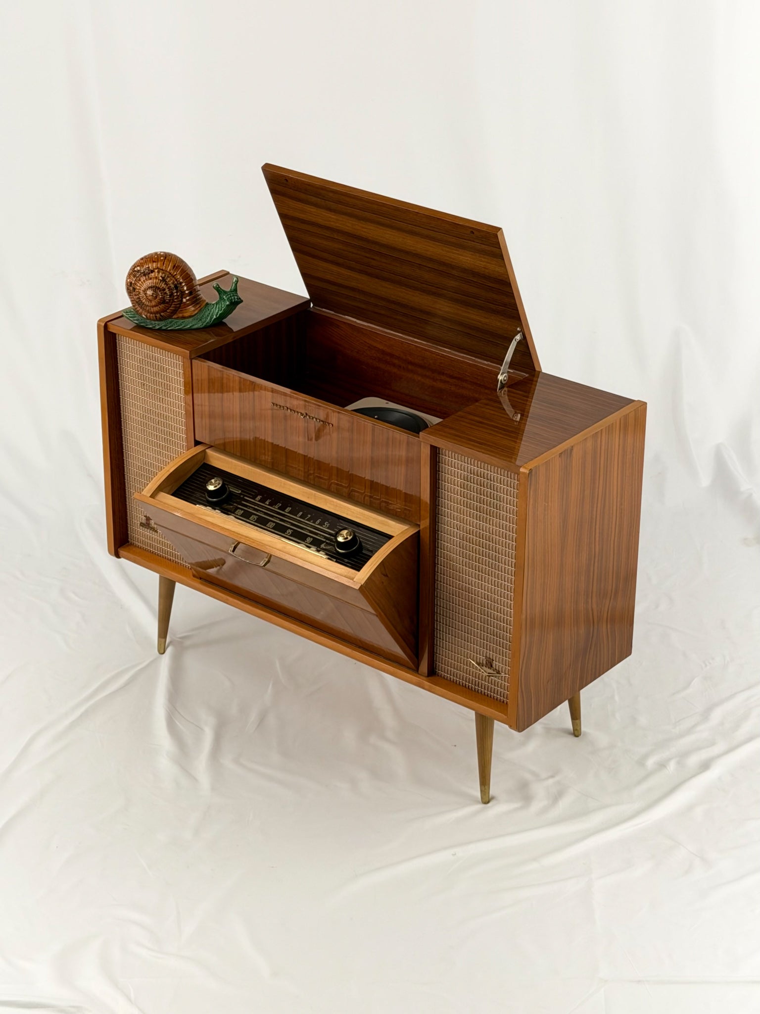 Vintage record player with a turntable and control panel on a wooden surface.
