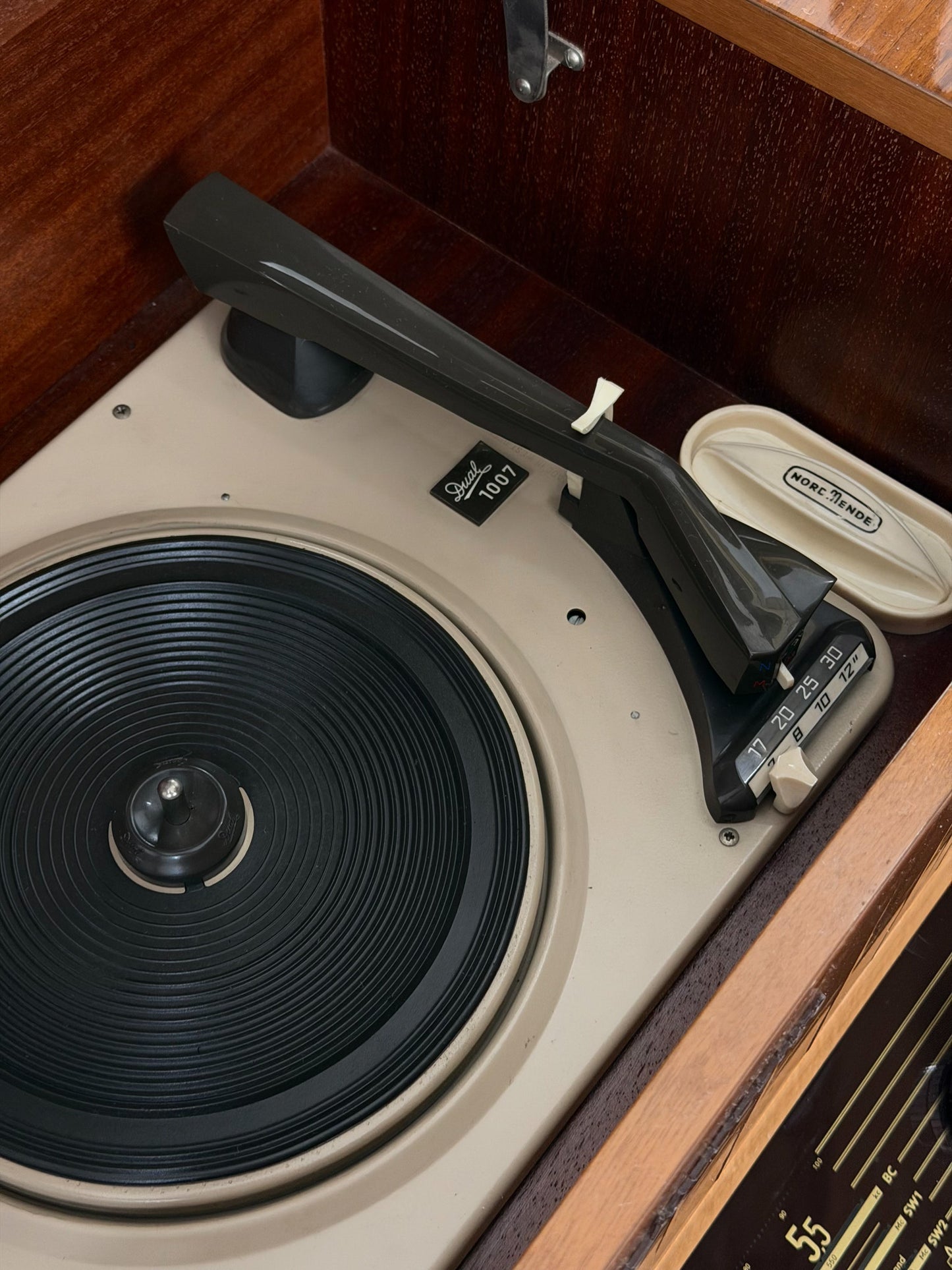 Vintage record player with a turntable and control panel on a wooden surface.