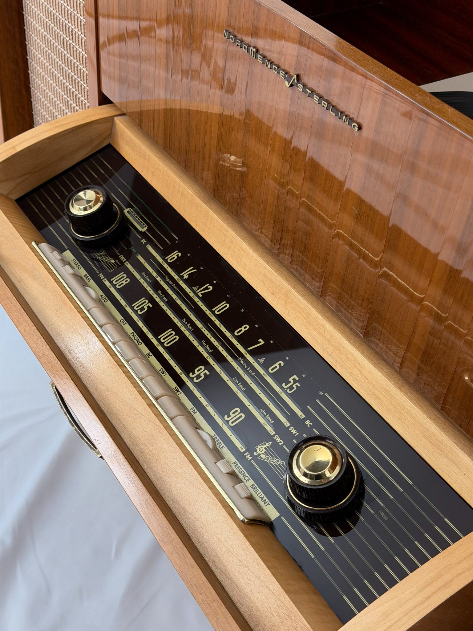 Vintage record player with a turntable and control panel on a wooden surface.