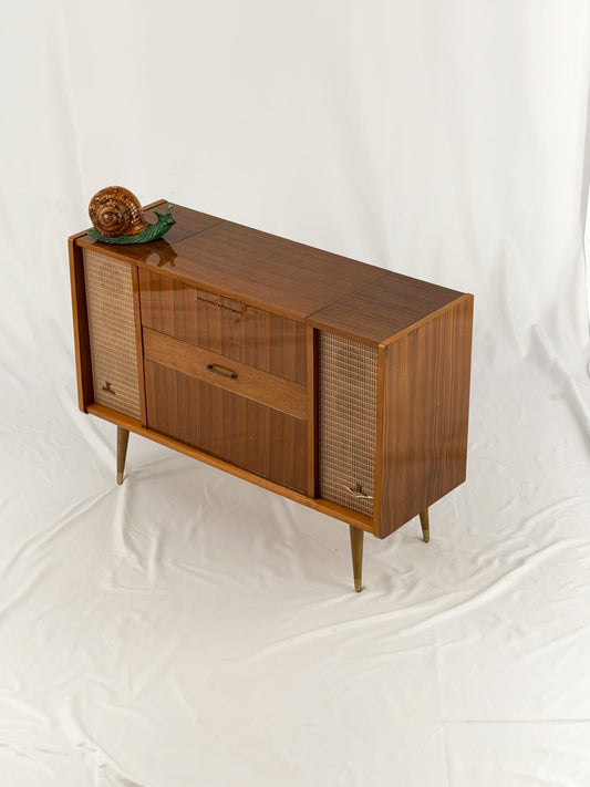 Vintage record player with a turntable and control panel on a wooden surface.