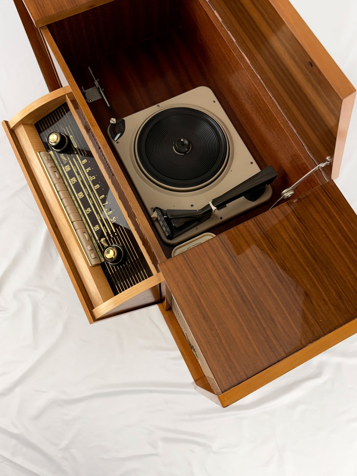 Vintage record player with a turntable and control panel on a wooden surface.