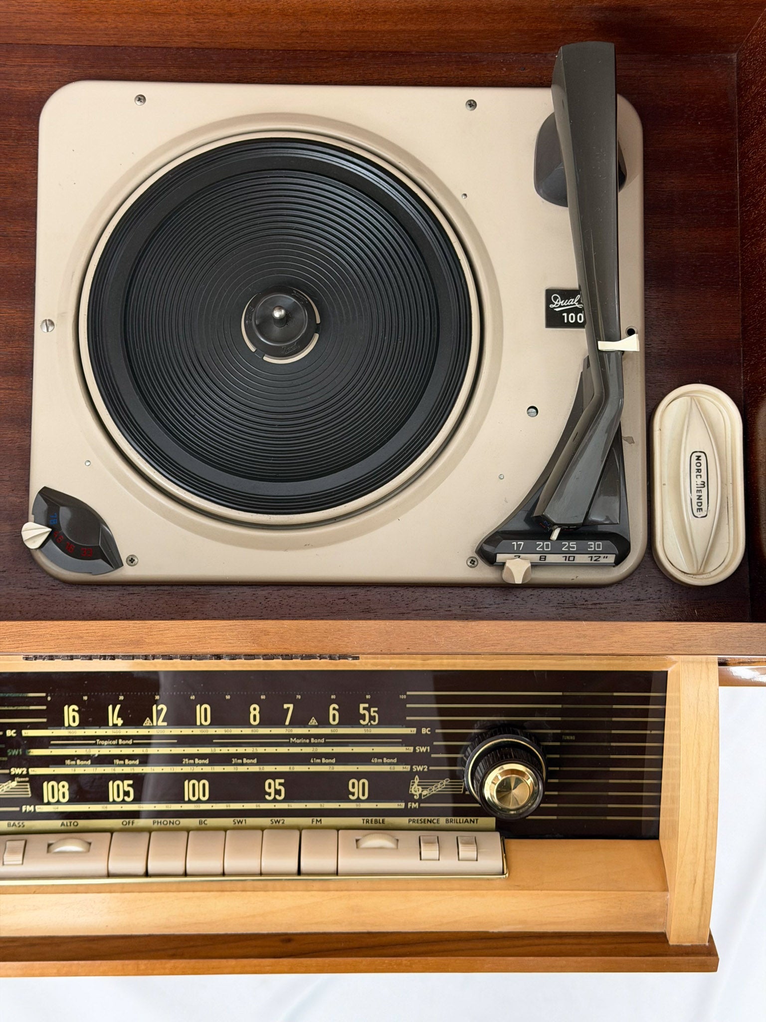 Vintage record player with a turntable and control panel on a wooden surface.