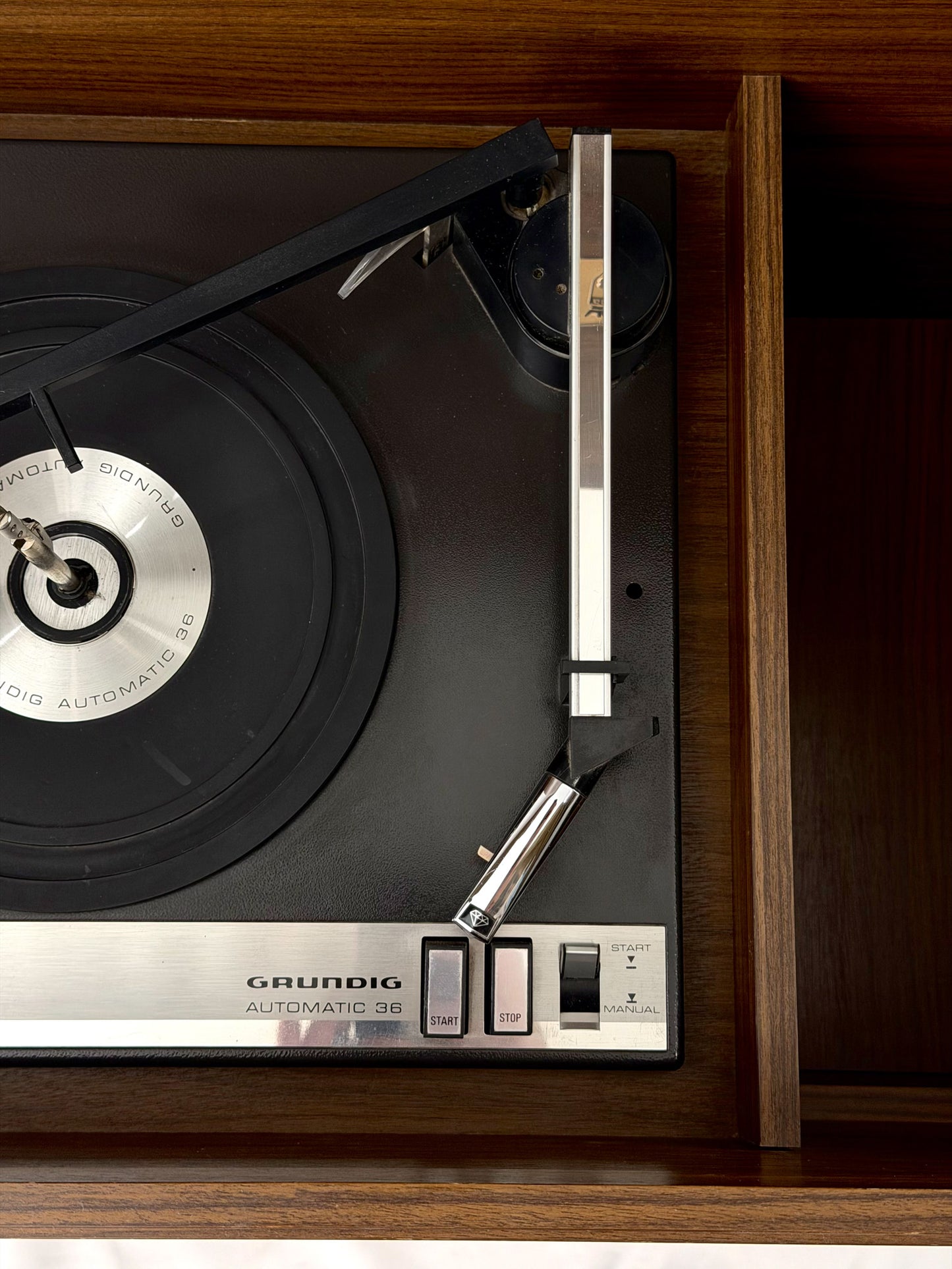 Close-up of a Grundig turntable with a record on a wooden surface