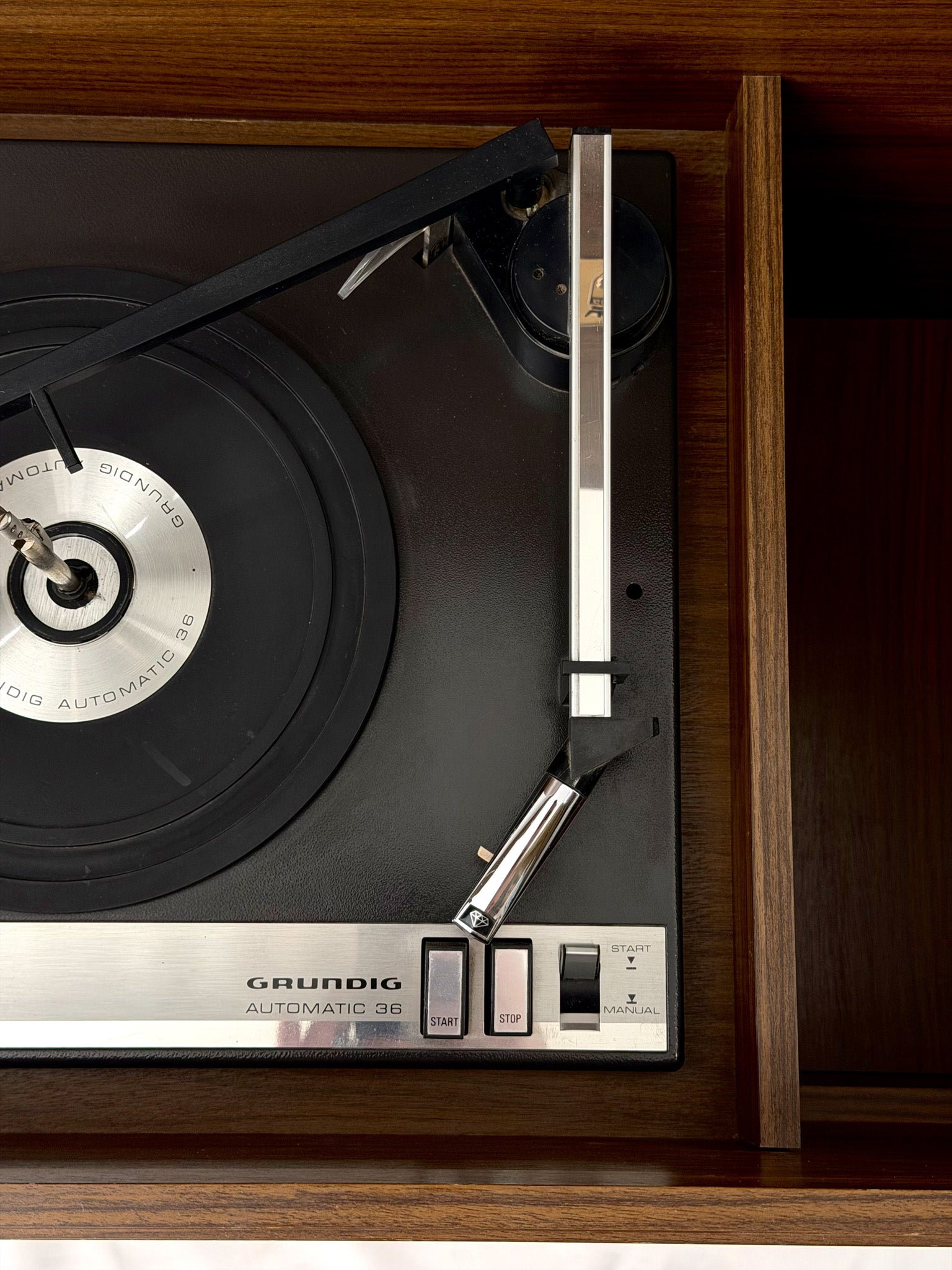 Close-up of a Grundig turntable with a record on a wooden surface