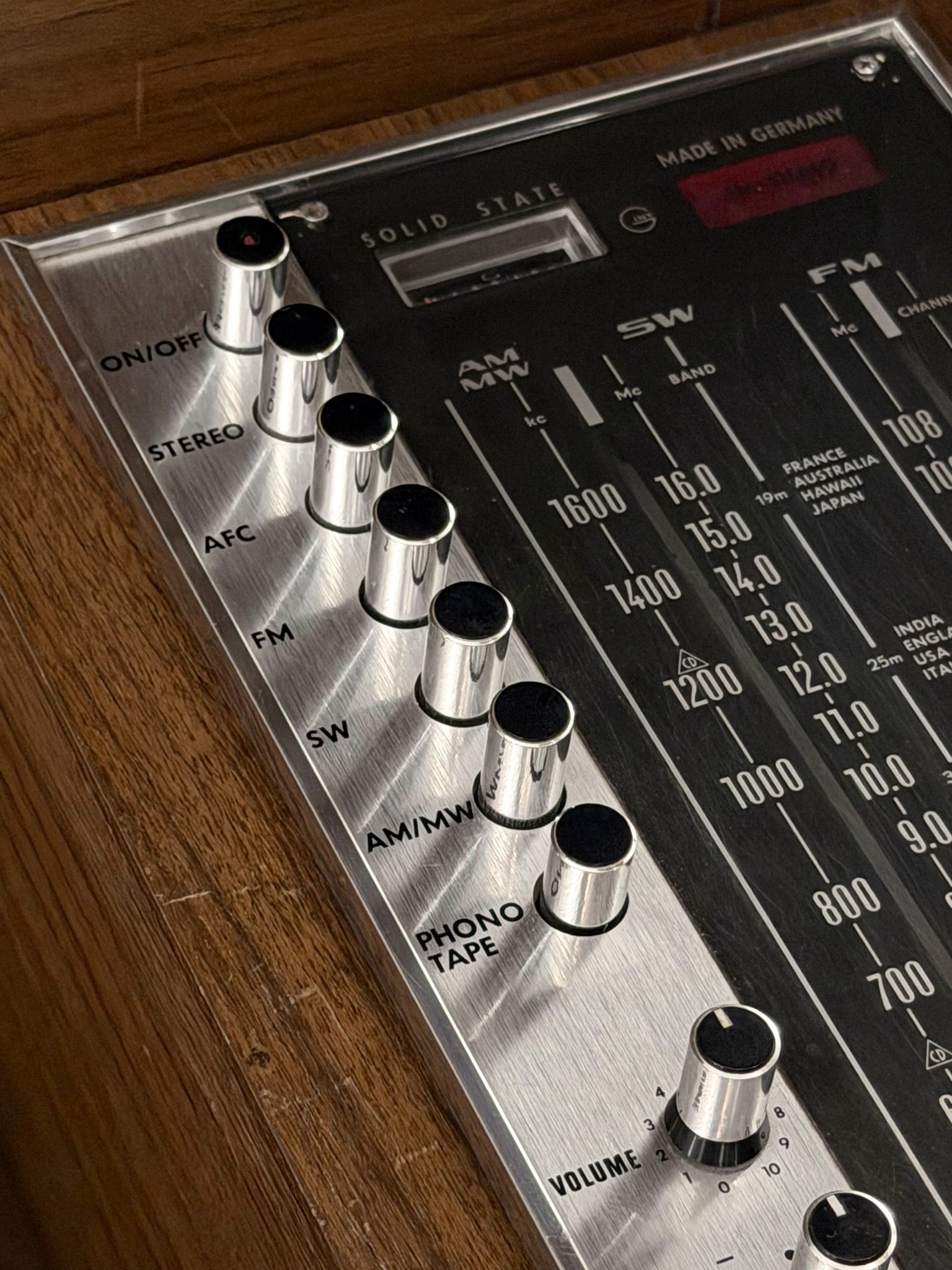 Vintage radio receiver with control knobs on a wooden surface