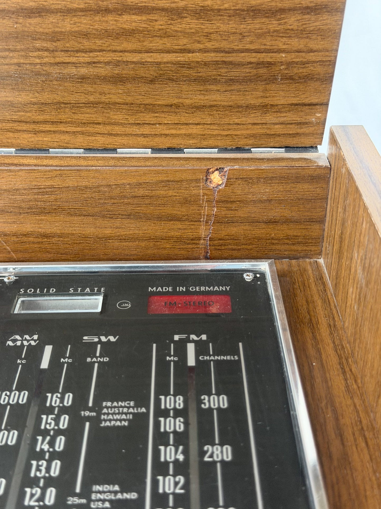 Vintage record player with a turntable and control panel on a wooden surface.