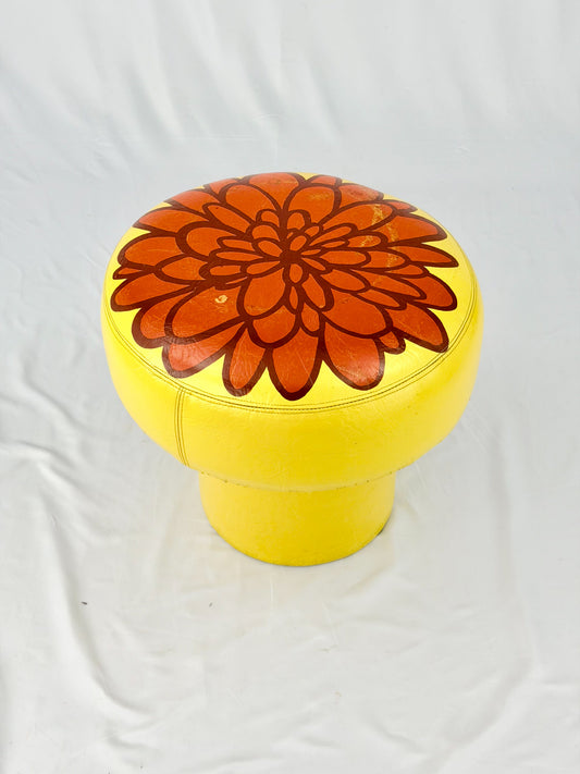 Yellow ottoman with a red floral design on a white background