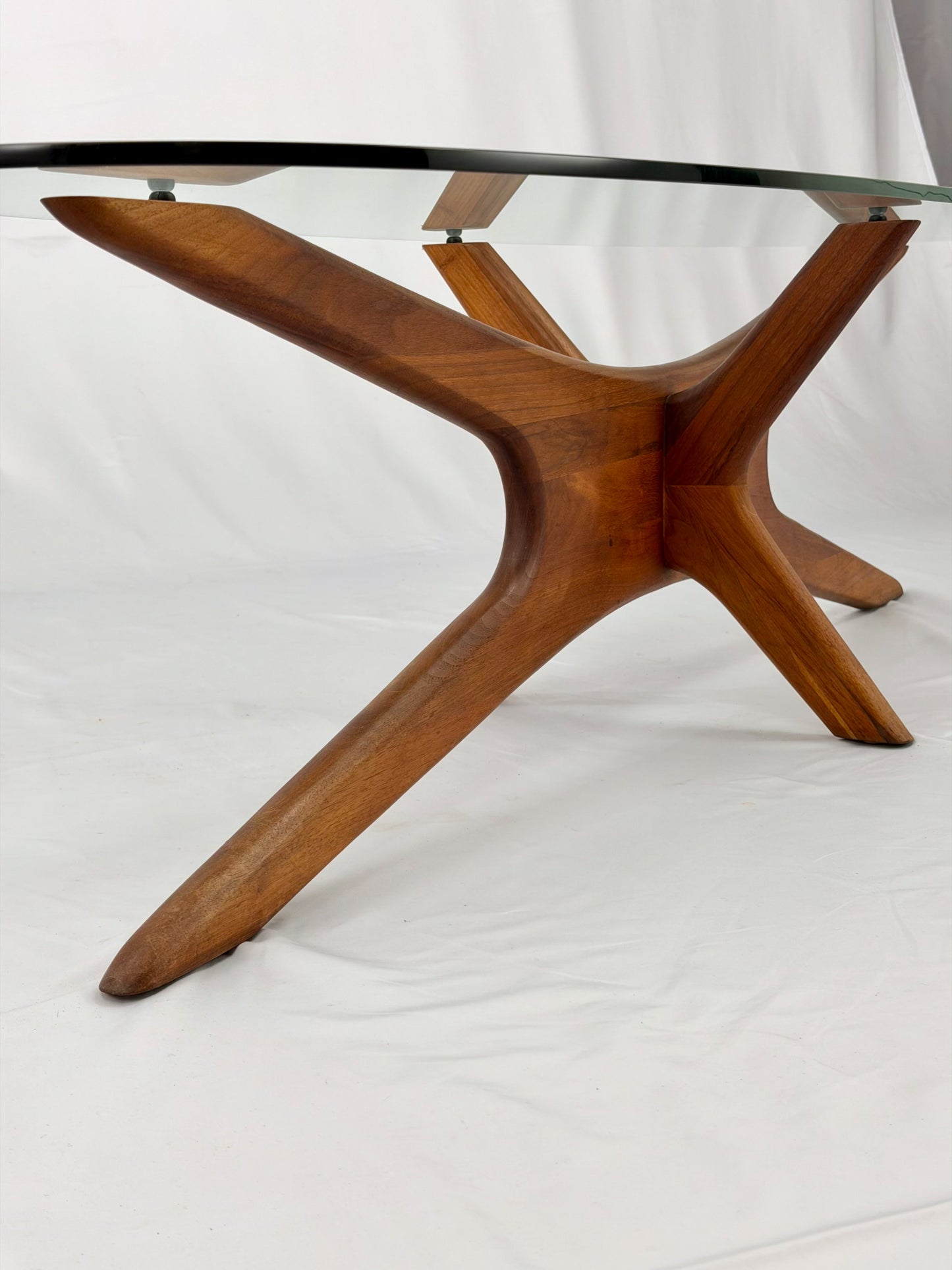 Glass-top table with wooden base on a white background