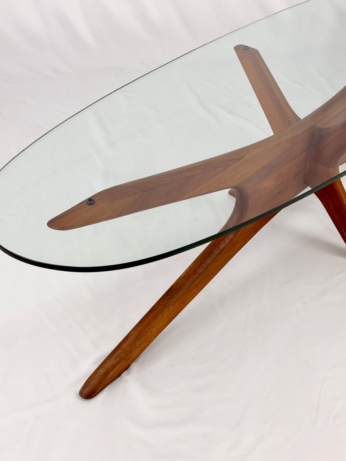Glass-top table with wooden base on a white background