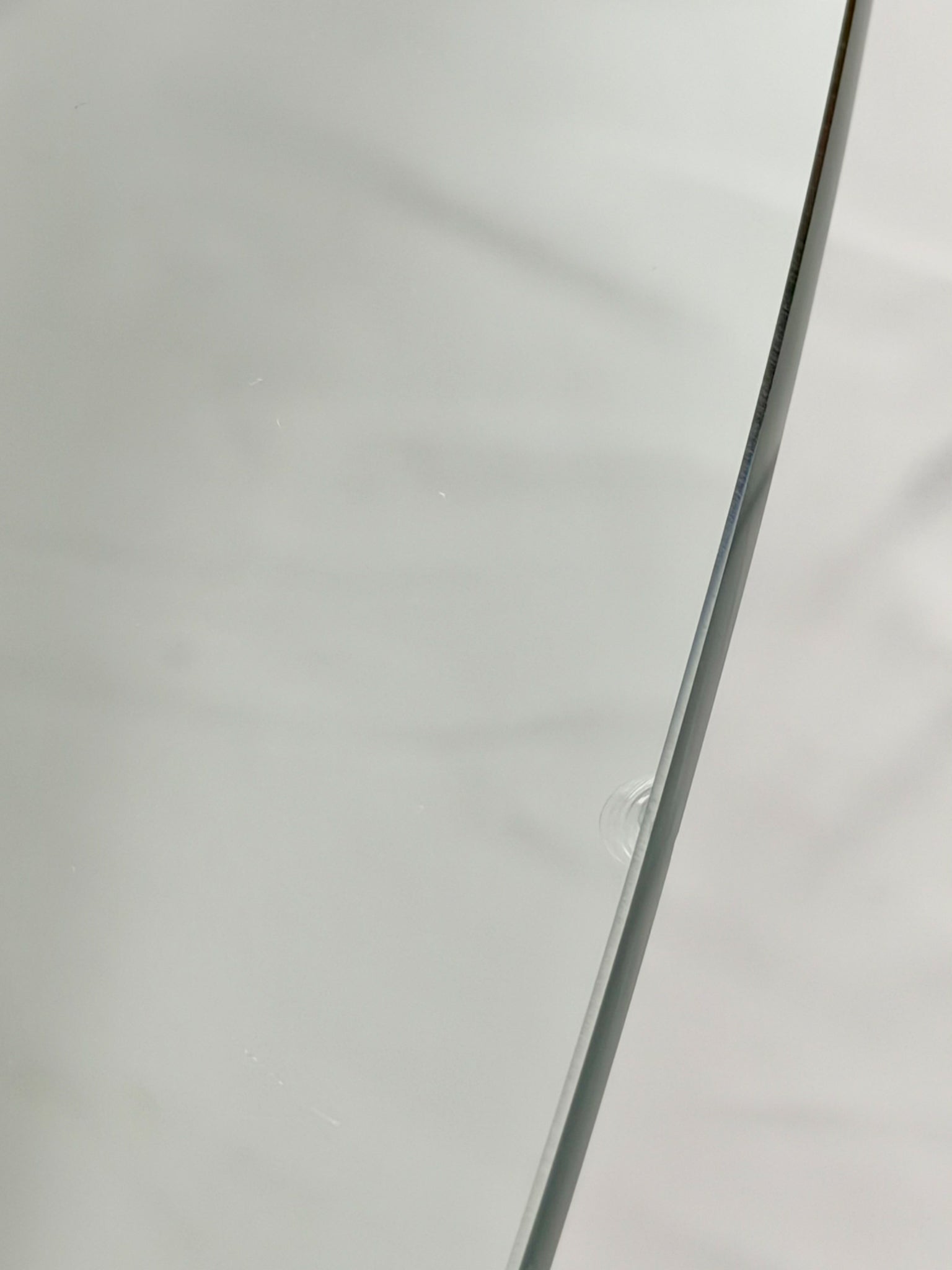 Glass-top table with wooden base on a white background