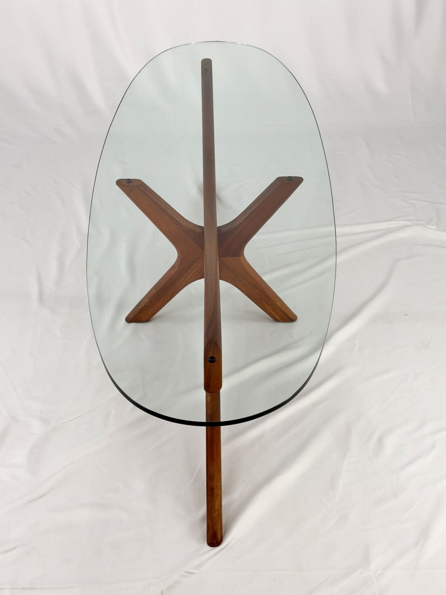 Glass-top table with wooden base on a white background