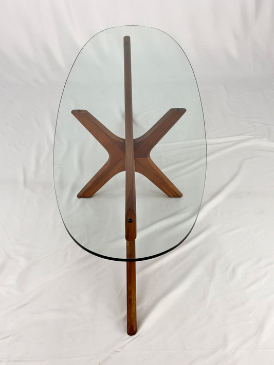 Glass-top table with wooden base on a white background