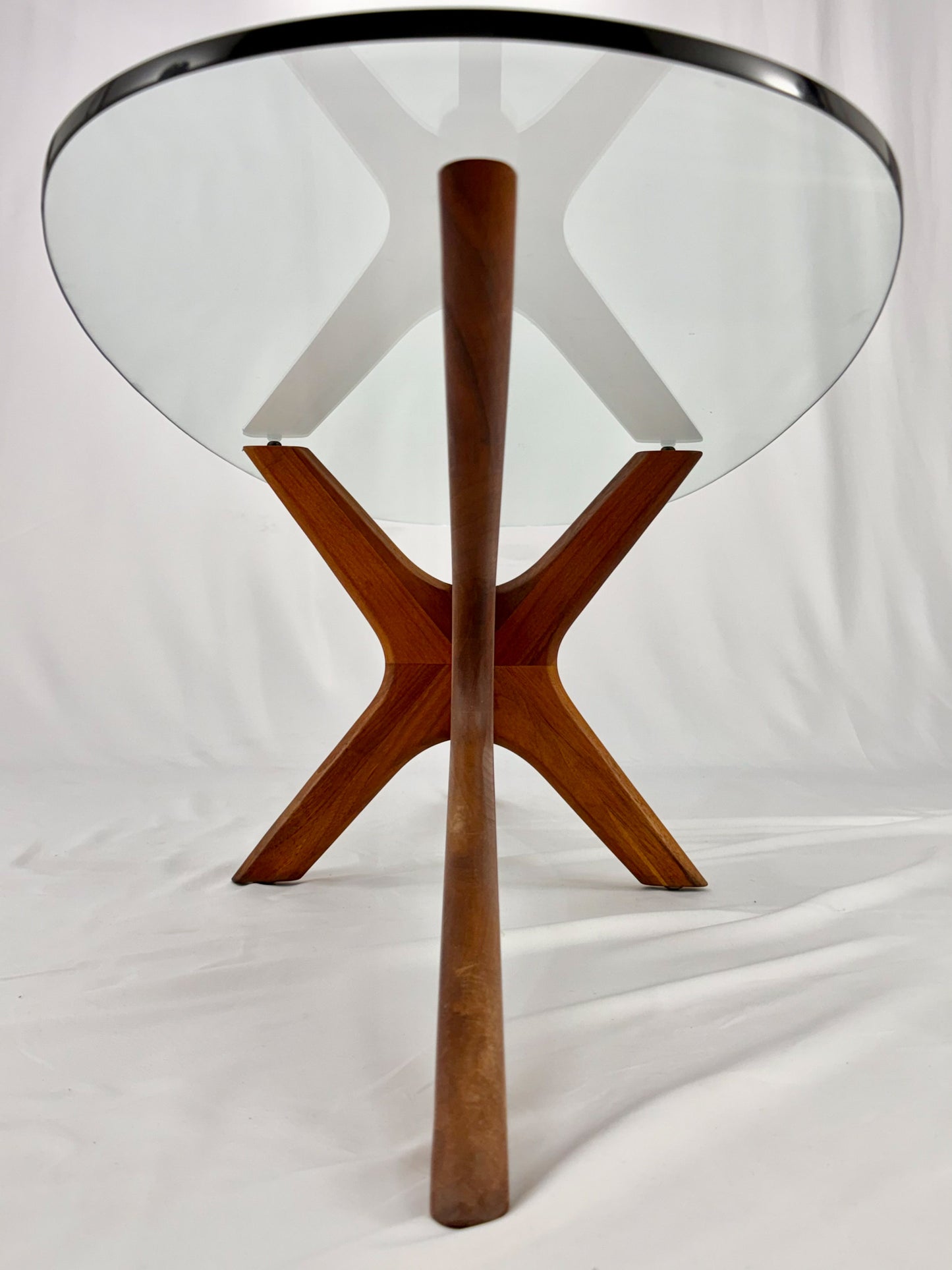 Glass-top table with wooden base on a white background