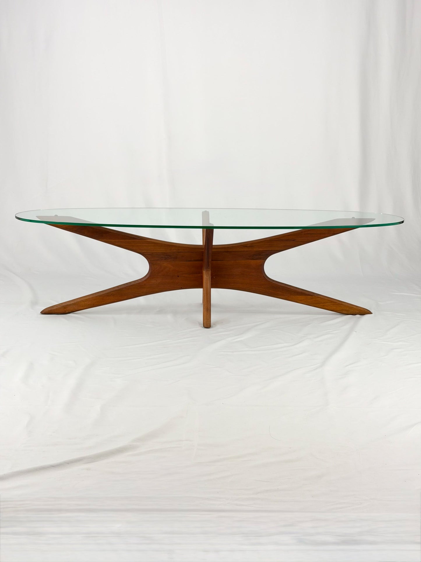 Glass-top table with wooden base on a white background