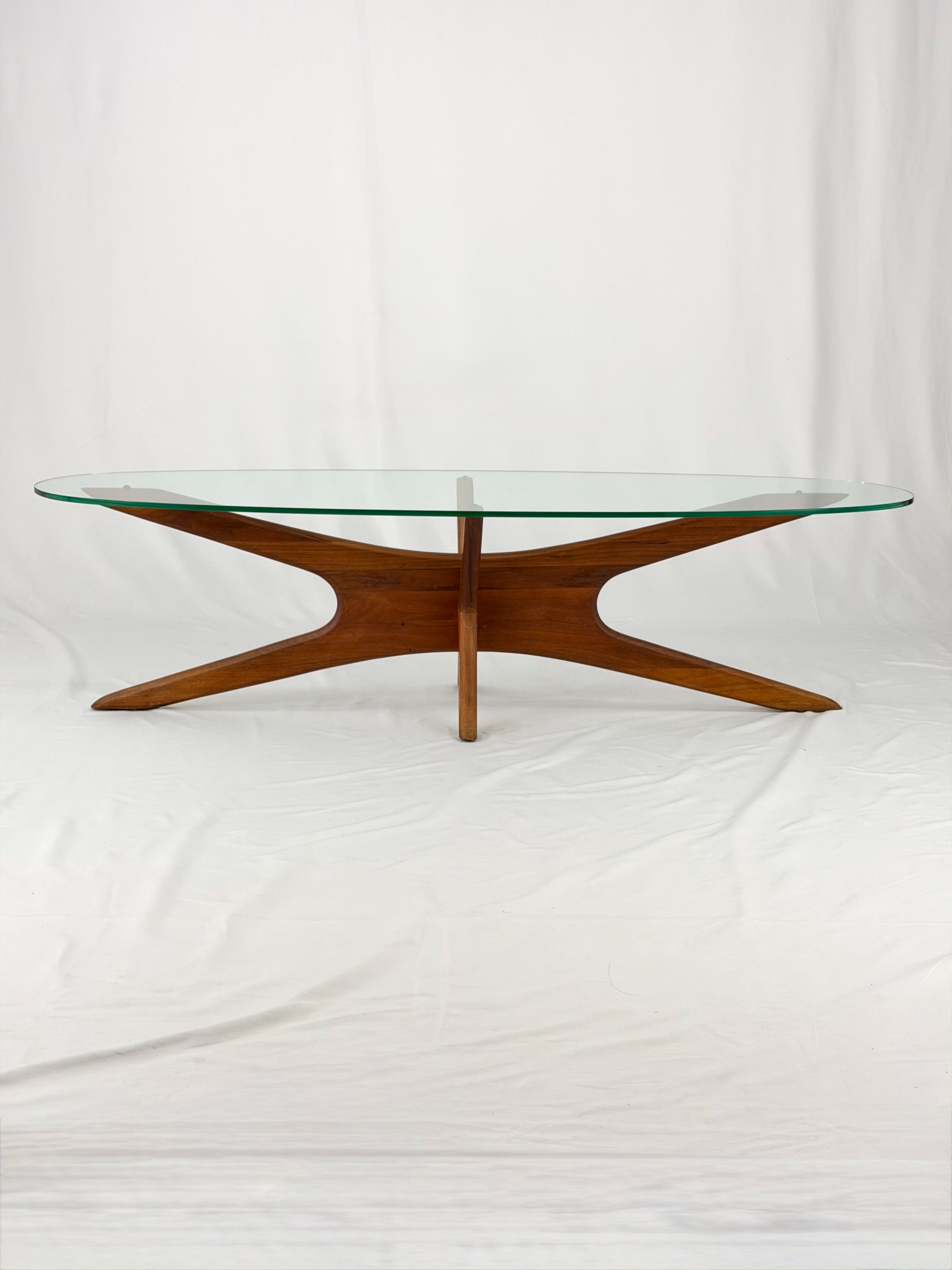 Glass-top table with wooden base on a white background