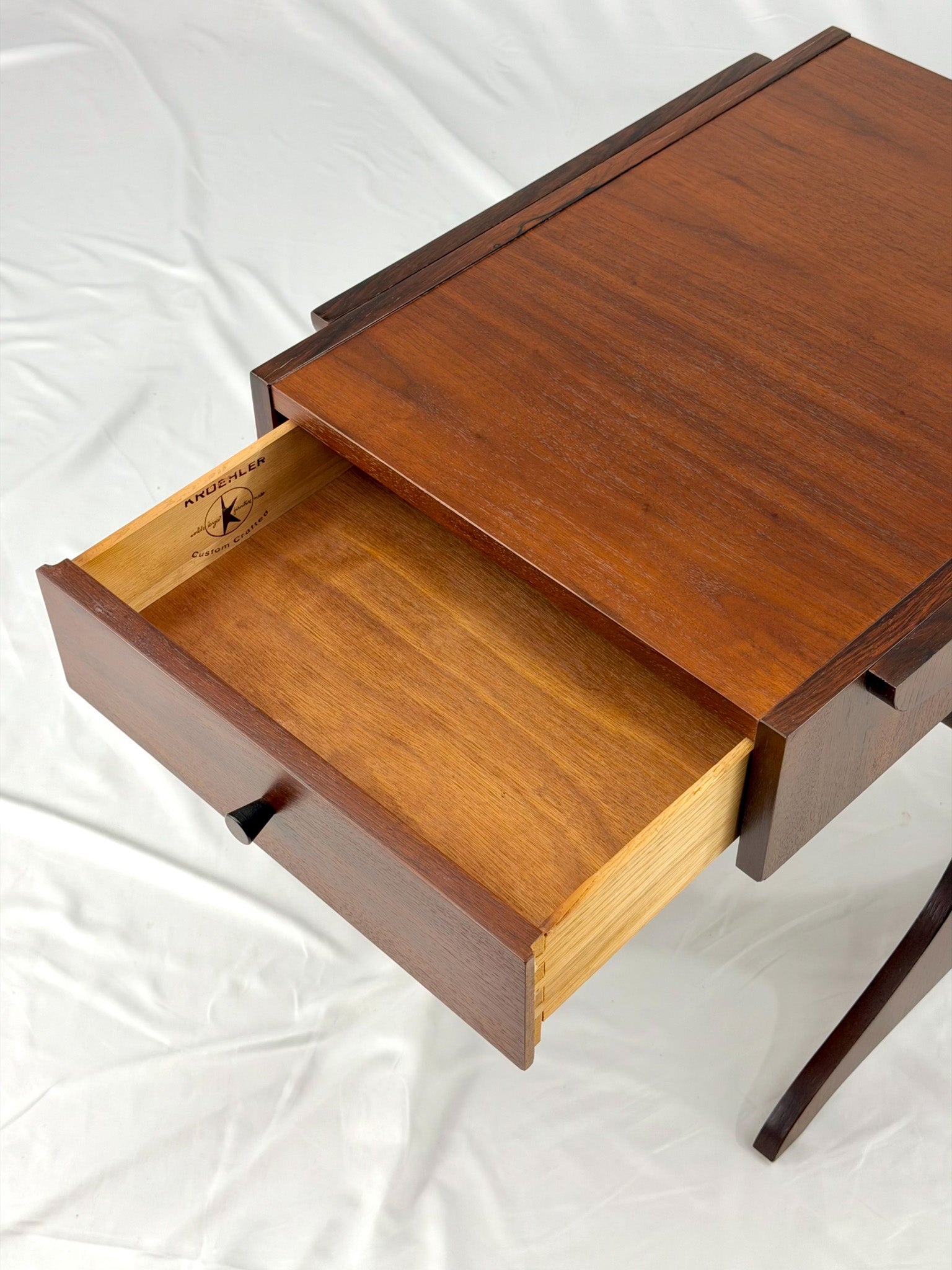 Wooden side table with drawers on a white background