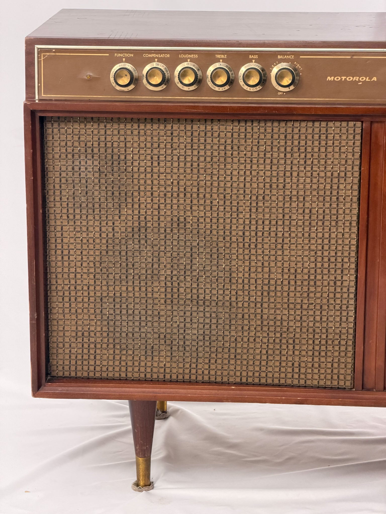 Vintage Motorola radio with wooden casing and control knobs on a white background