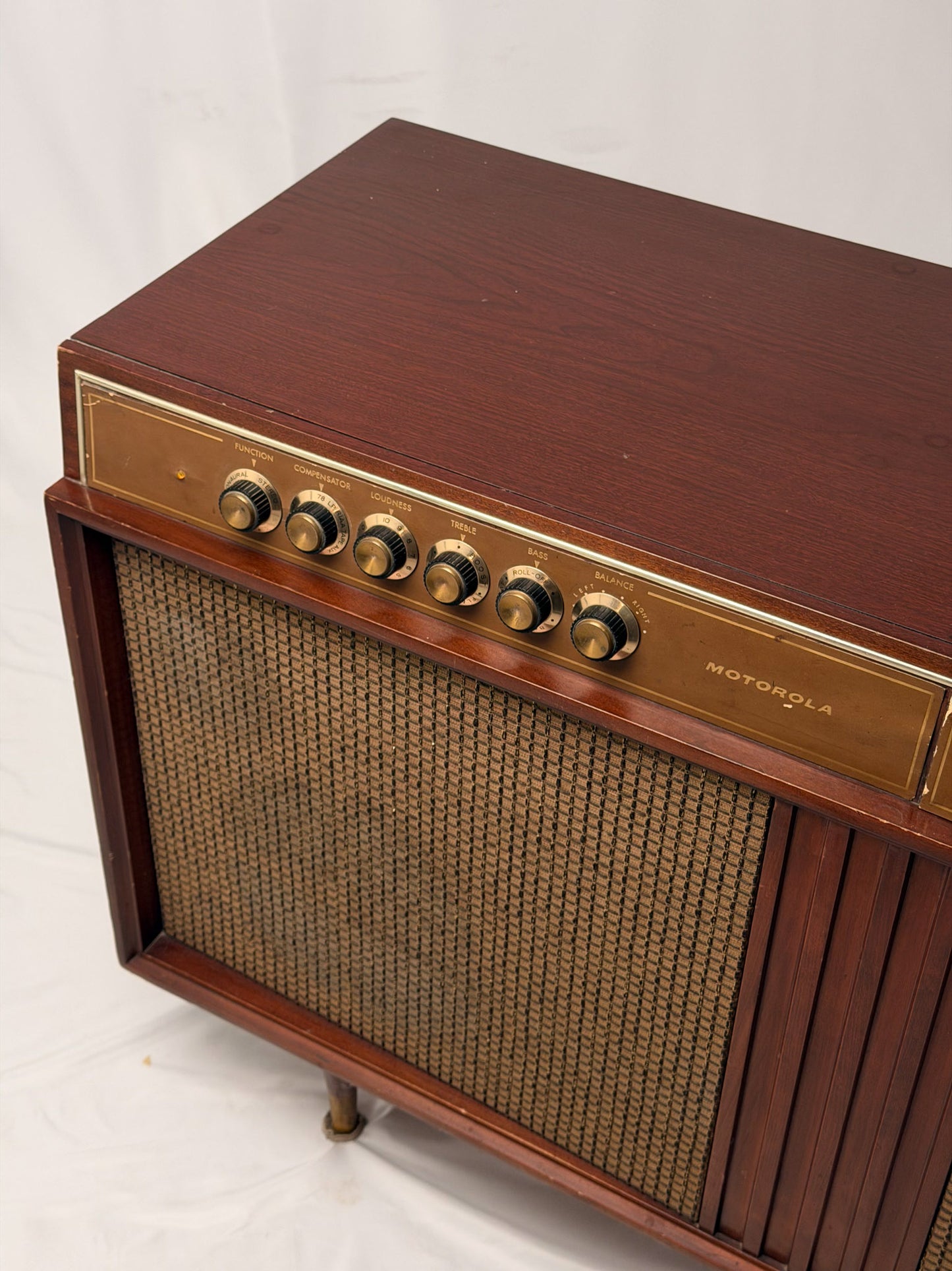 Vintage Motorola radio with wooden casing and control knobs on a white background