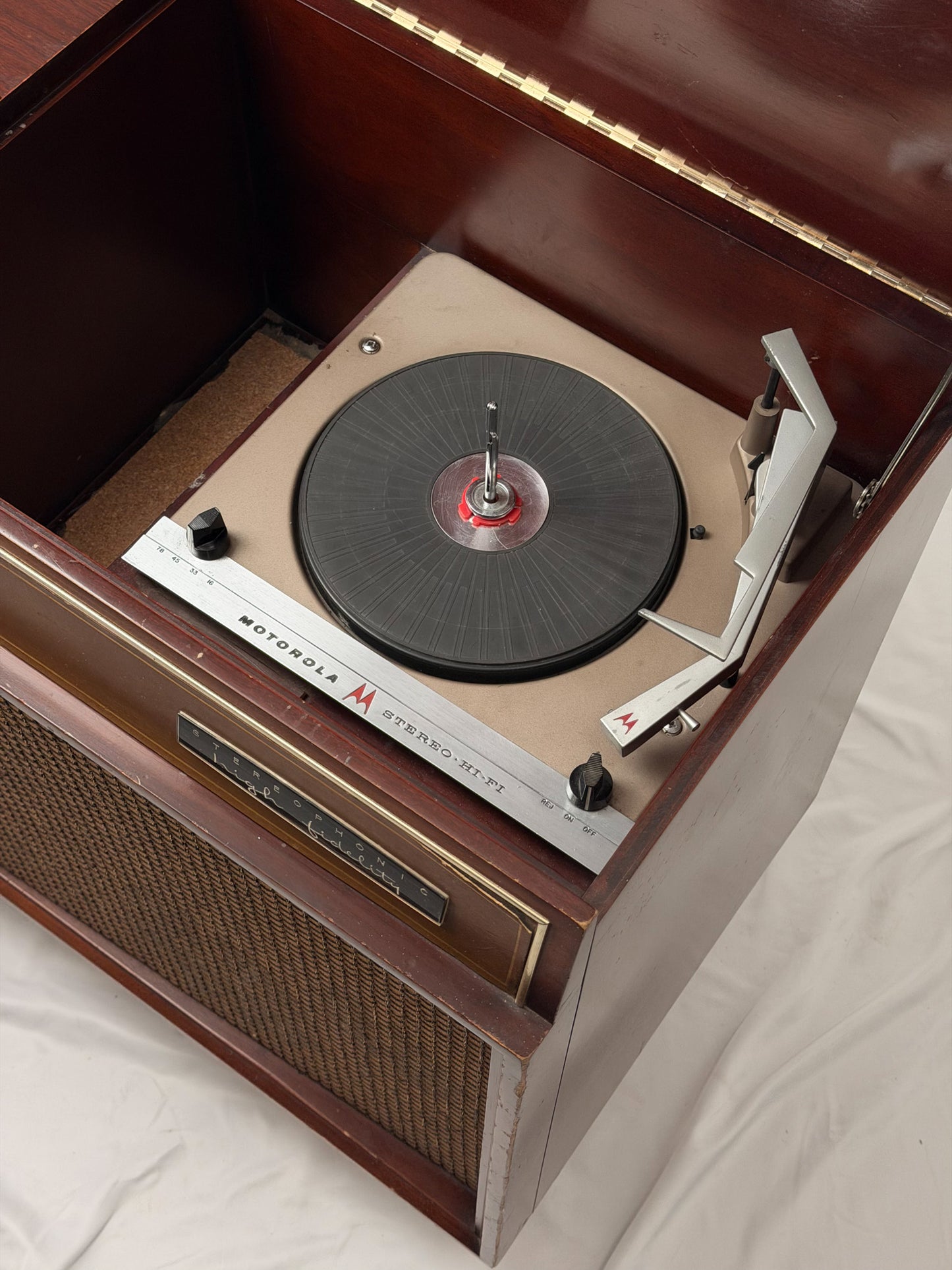 Vintage Motorola radio with wooden casing and control knobs on a white background