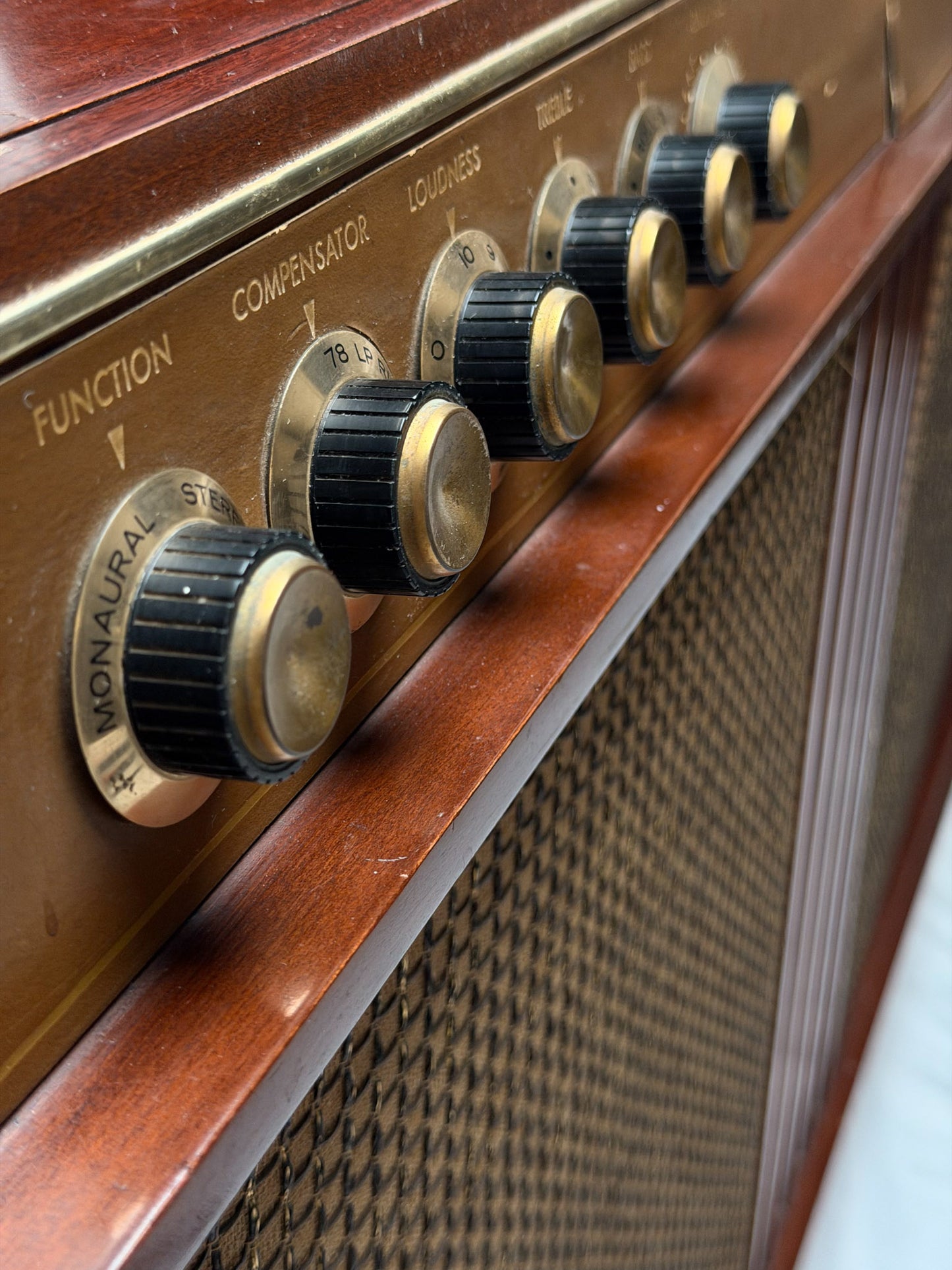 Vintage Motorola radio with wooden casing and control knobs on a white background