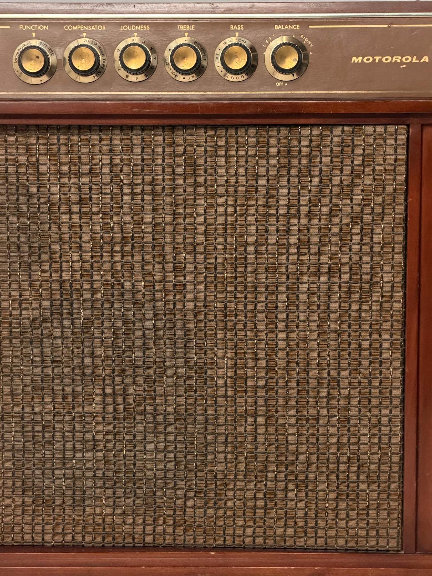 Vintage Motorola radio with wooden casing and control knobs on a white background