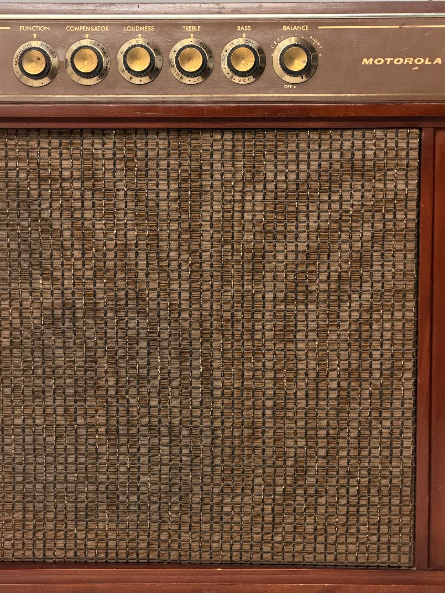 Vintage Motorola radio with wooden casing and control knobs on a white background