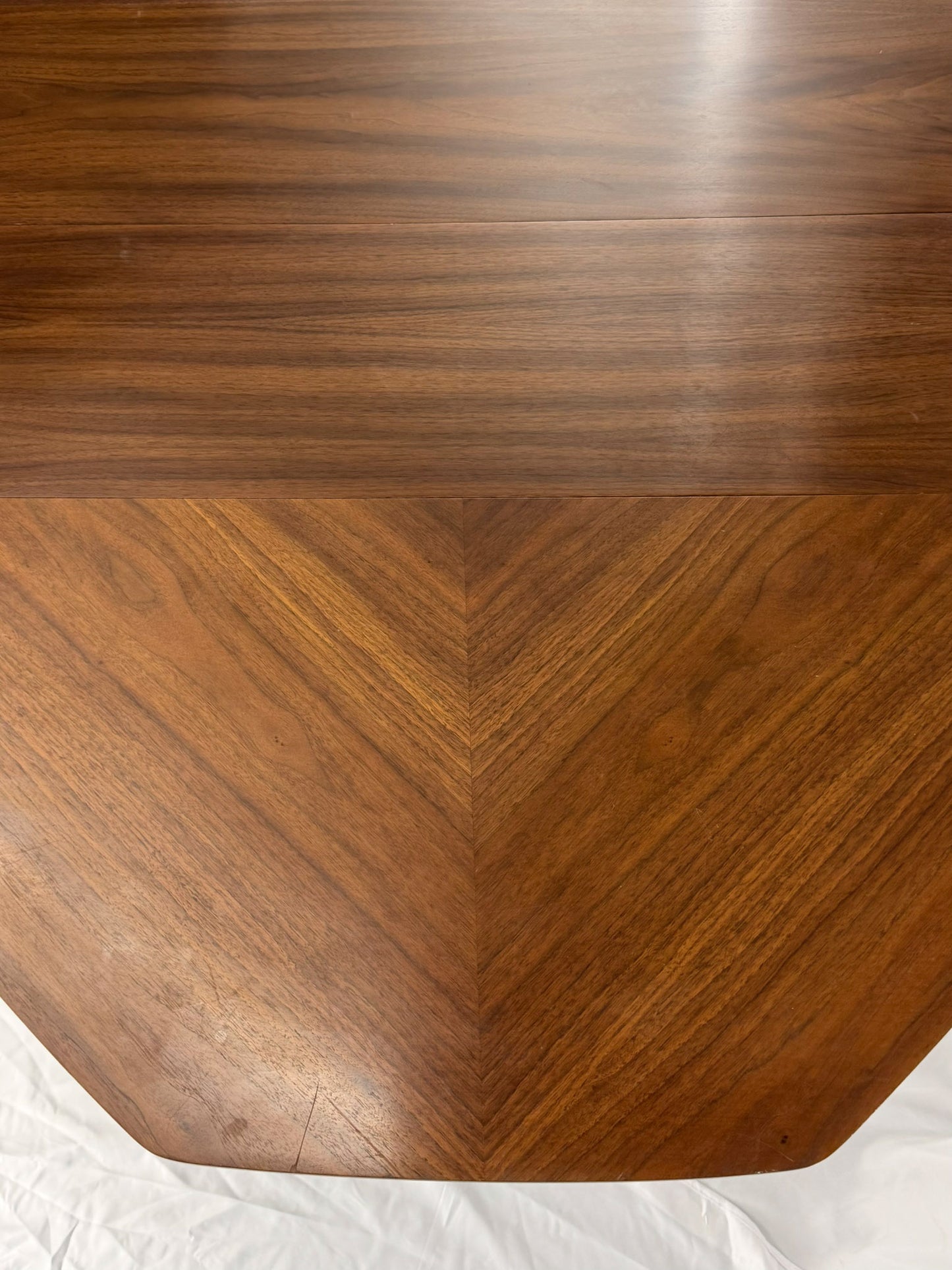 Wooden table top with a chevron pattern on a white background