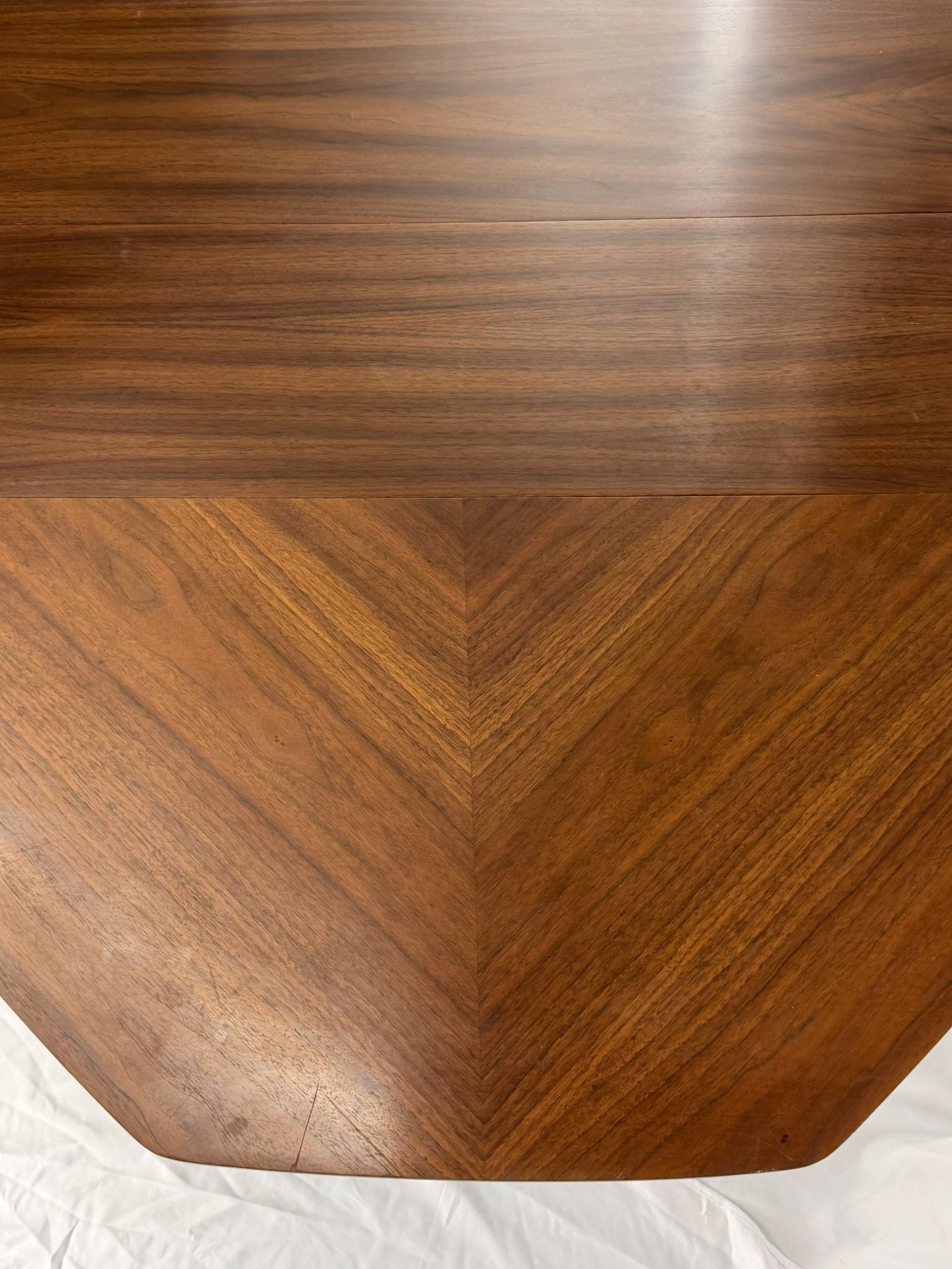 Wooden table top with a chevron pattern on a white background