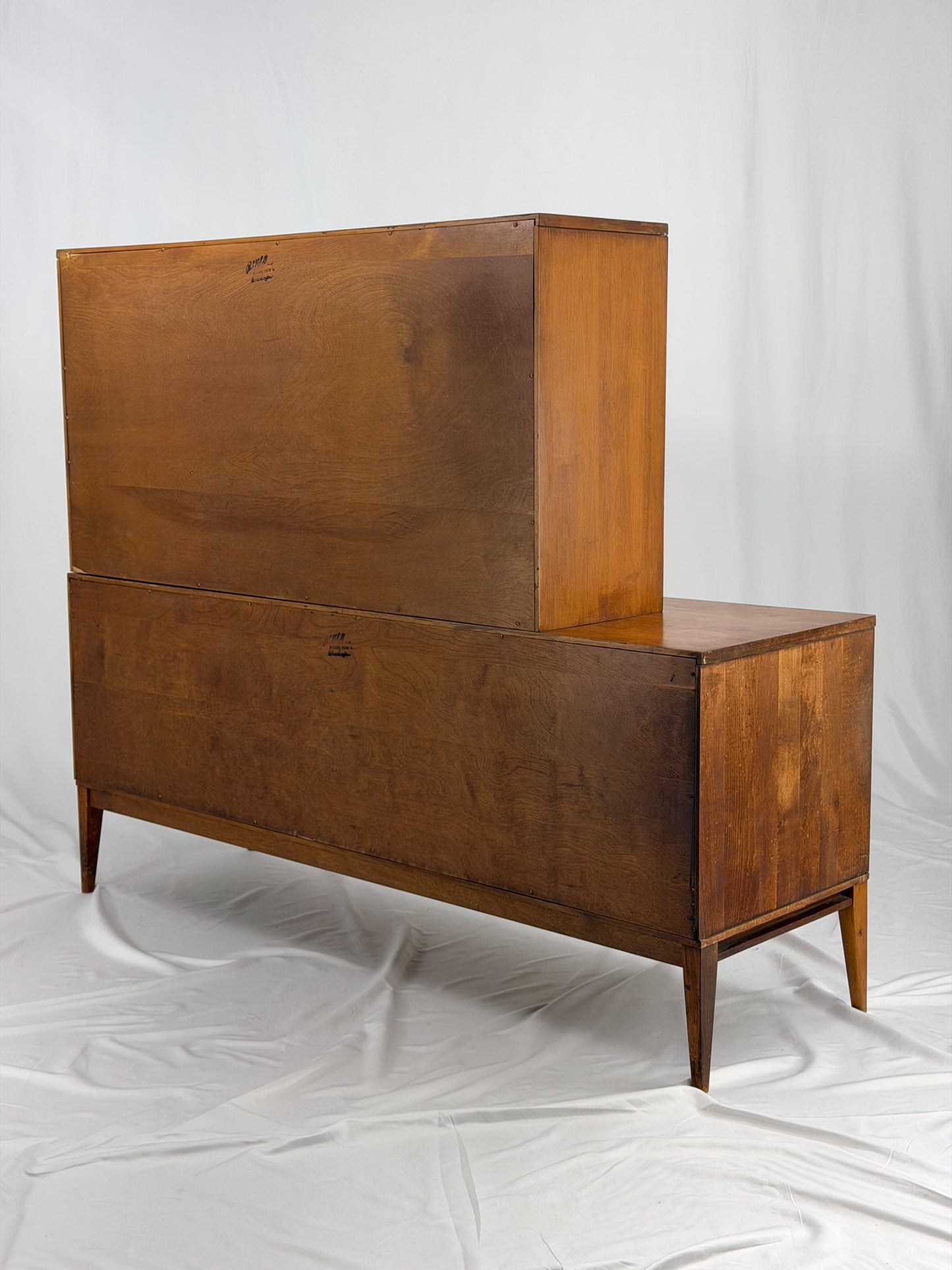 Wooden entertainment console with orange cabinet and open shelf on a white background