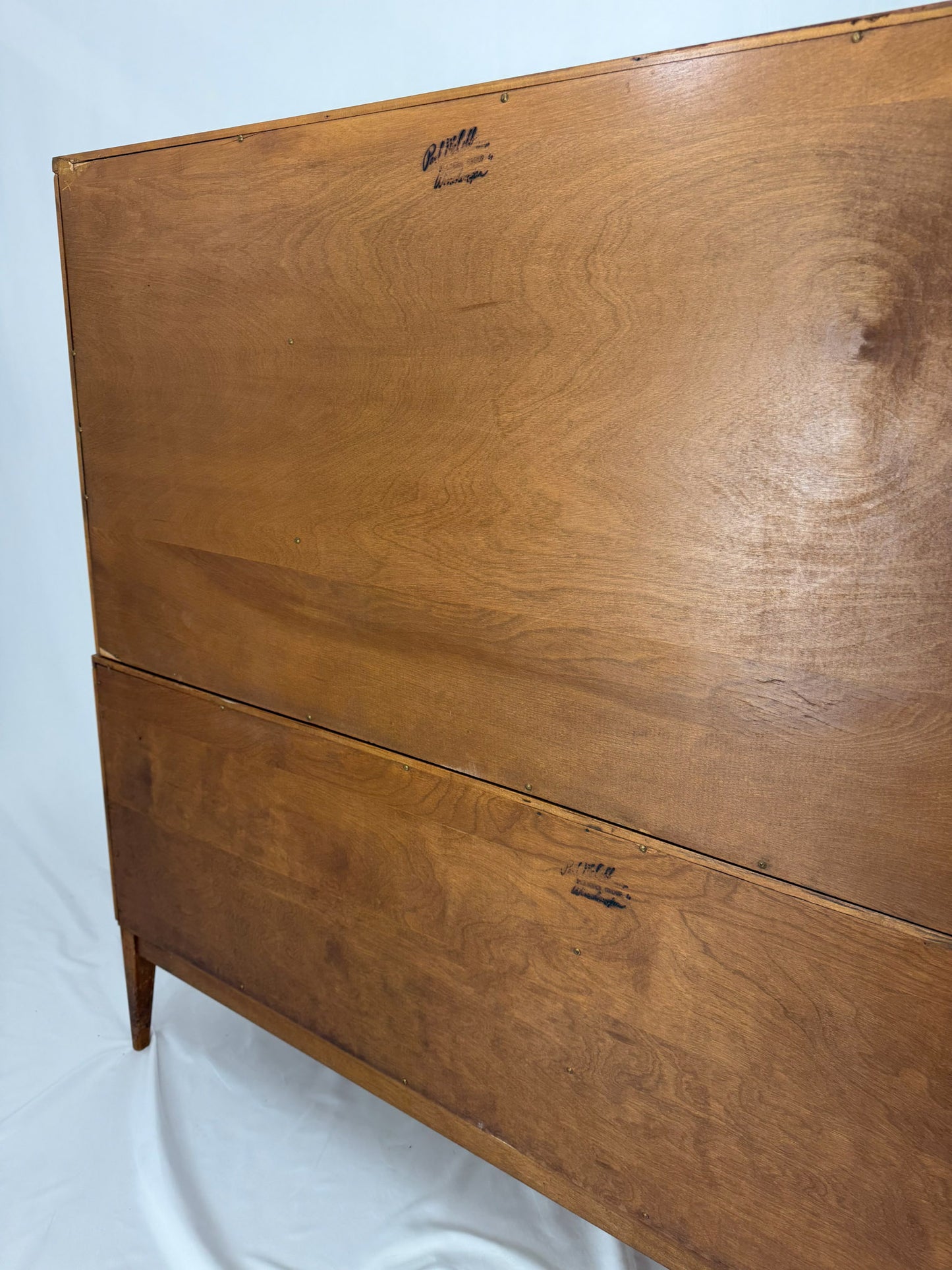 Wooden entertainment console with orange cabinet and open shelf on a white background