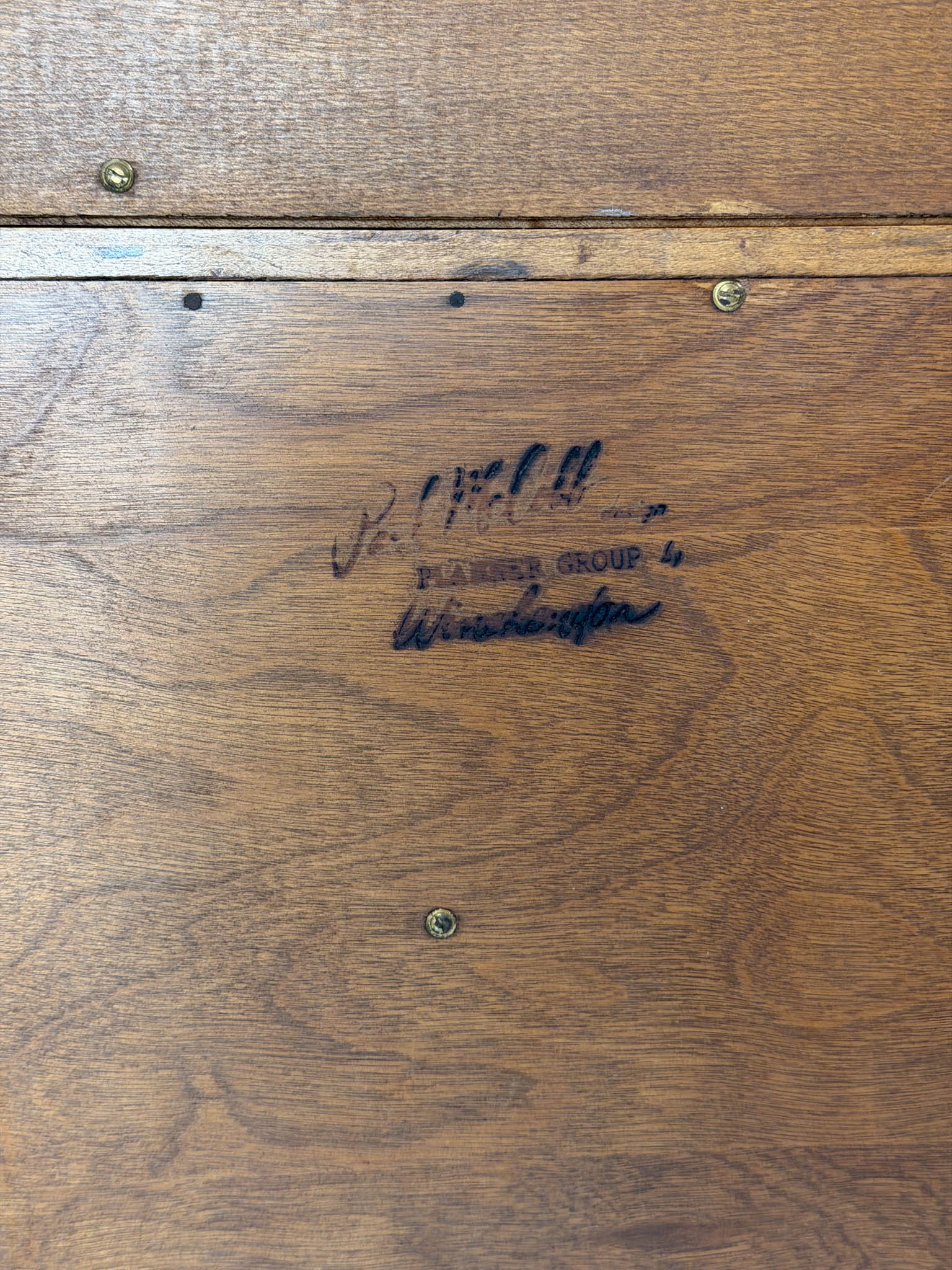 Wooden surface with a signature and text, likely a product label.