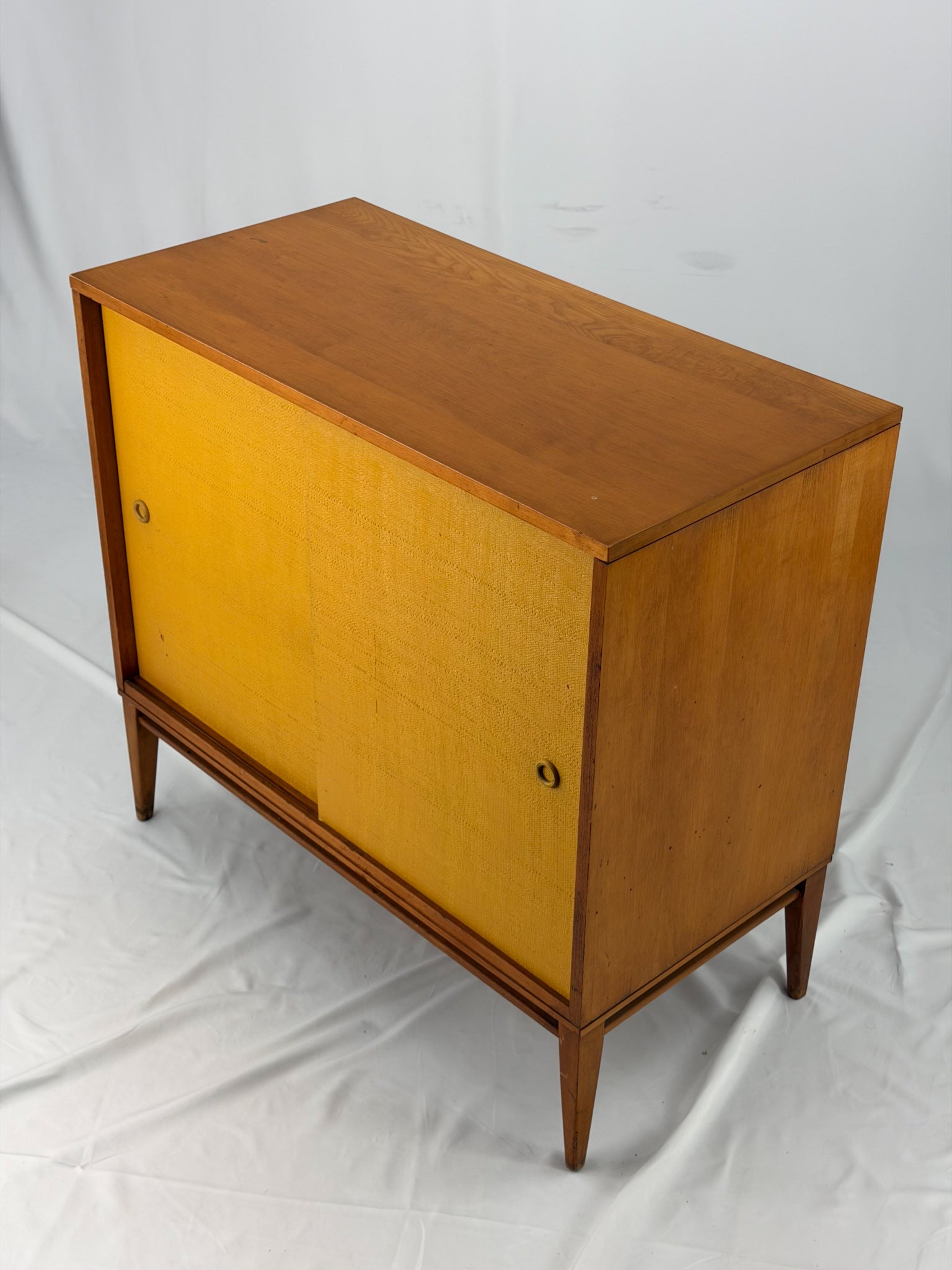 Wooden cabinet with yellow doors on a white background