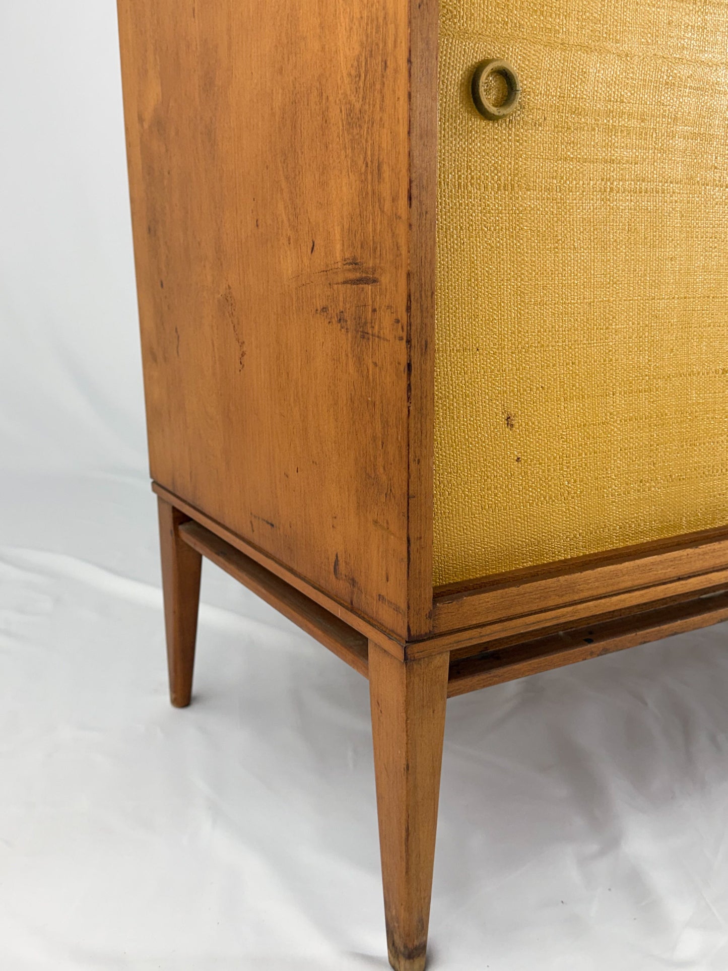 Wooden cabinet with a textured yellow door on a white background