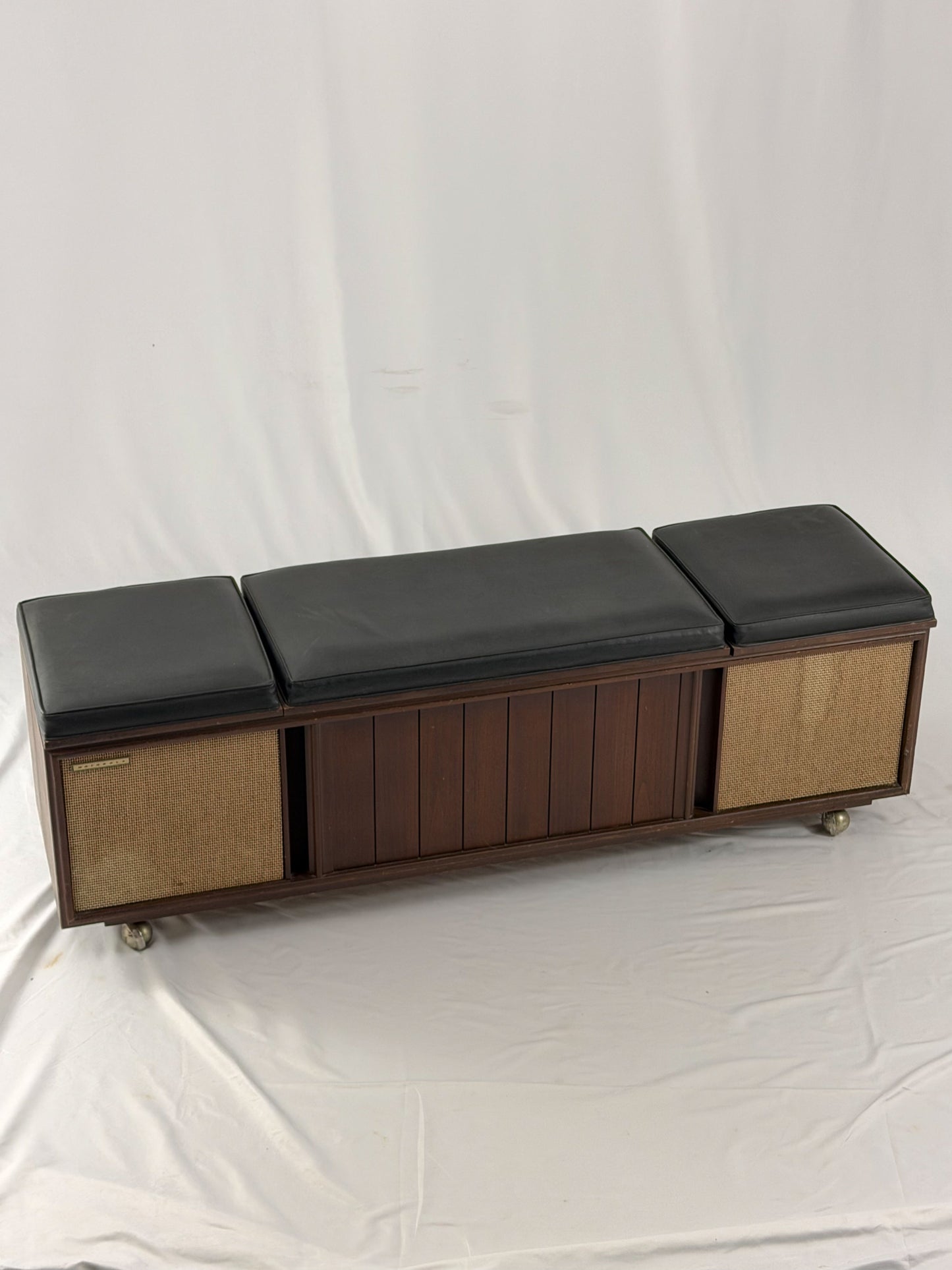 Wooden bench with black cushioned seats and storage drawers on a white background