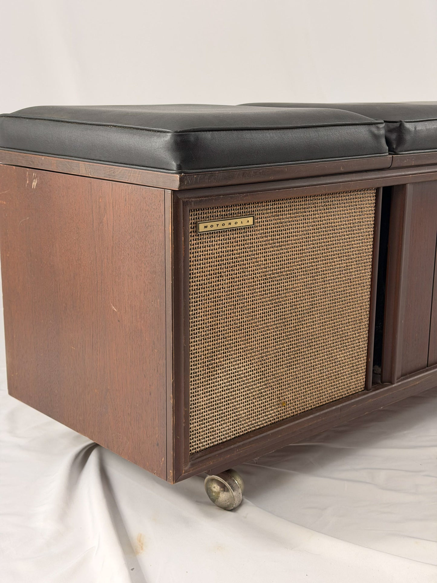 Wooden stereo console bench with padded black cusions on a white background