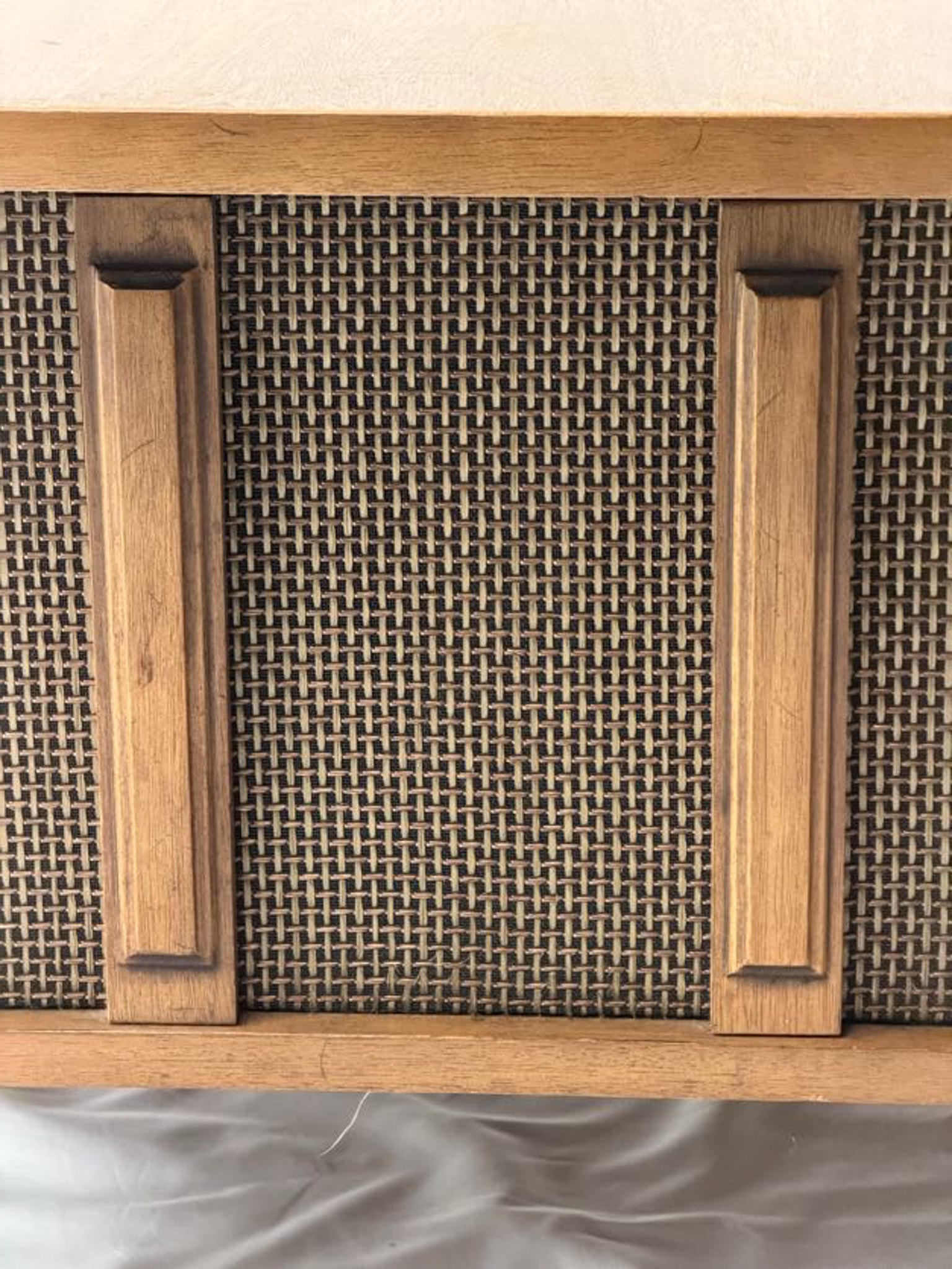 Wooden cabinet with woven design on a neutral background
