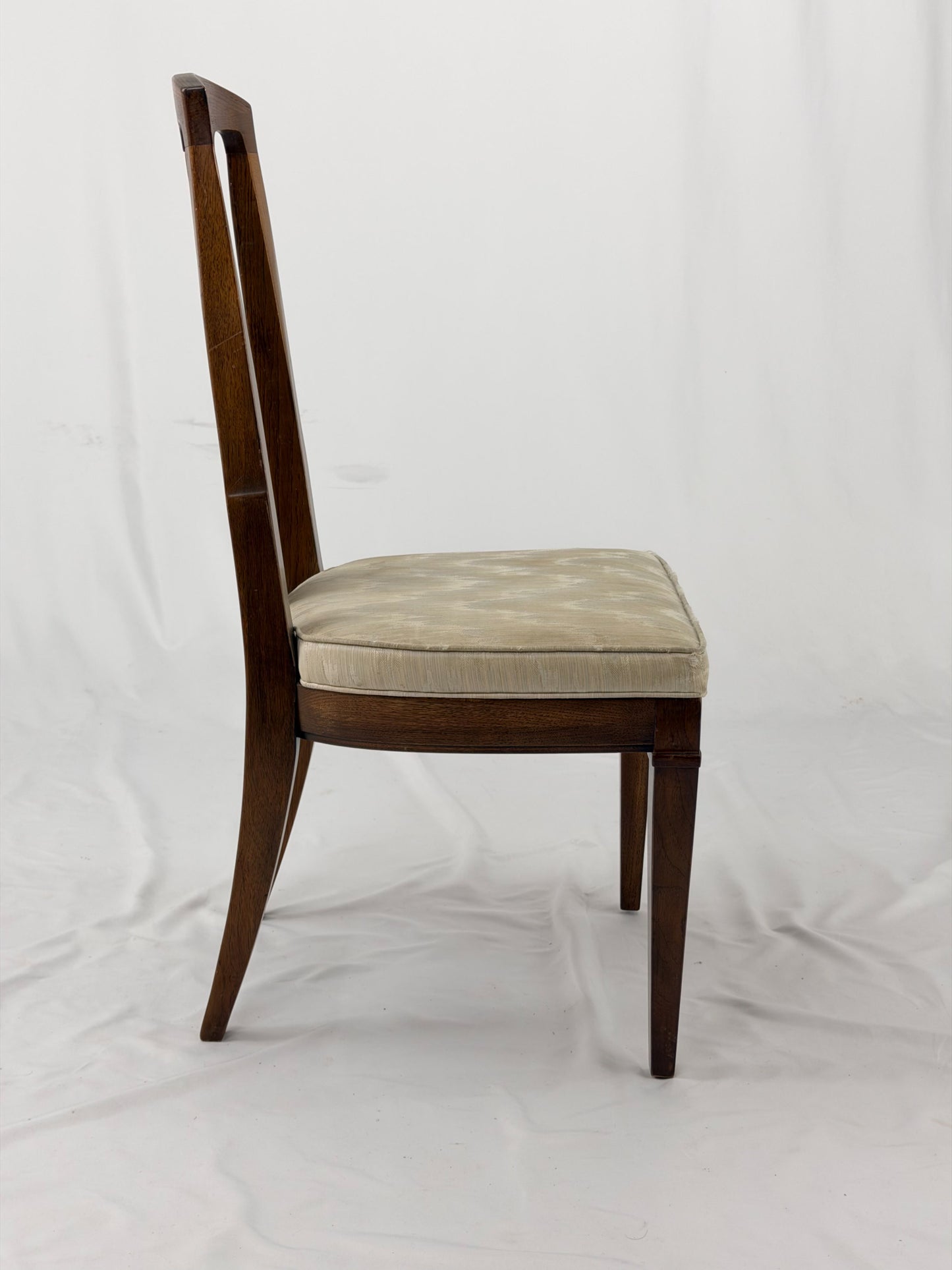 Wooden dining chair with a patterned cushion on a white background