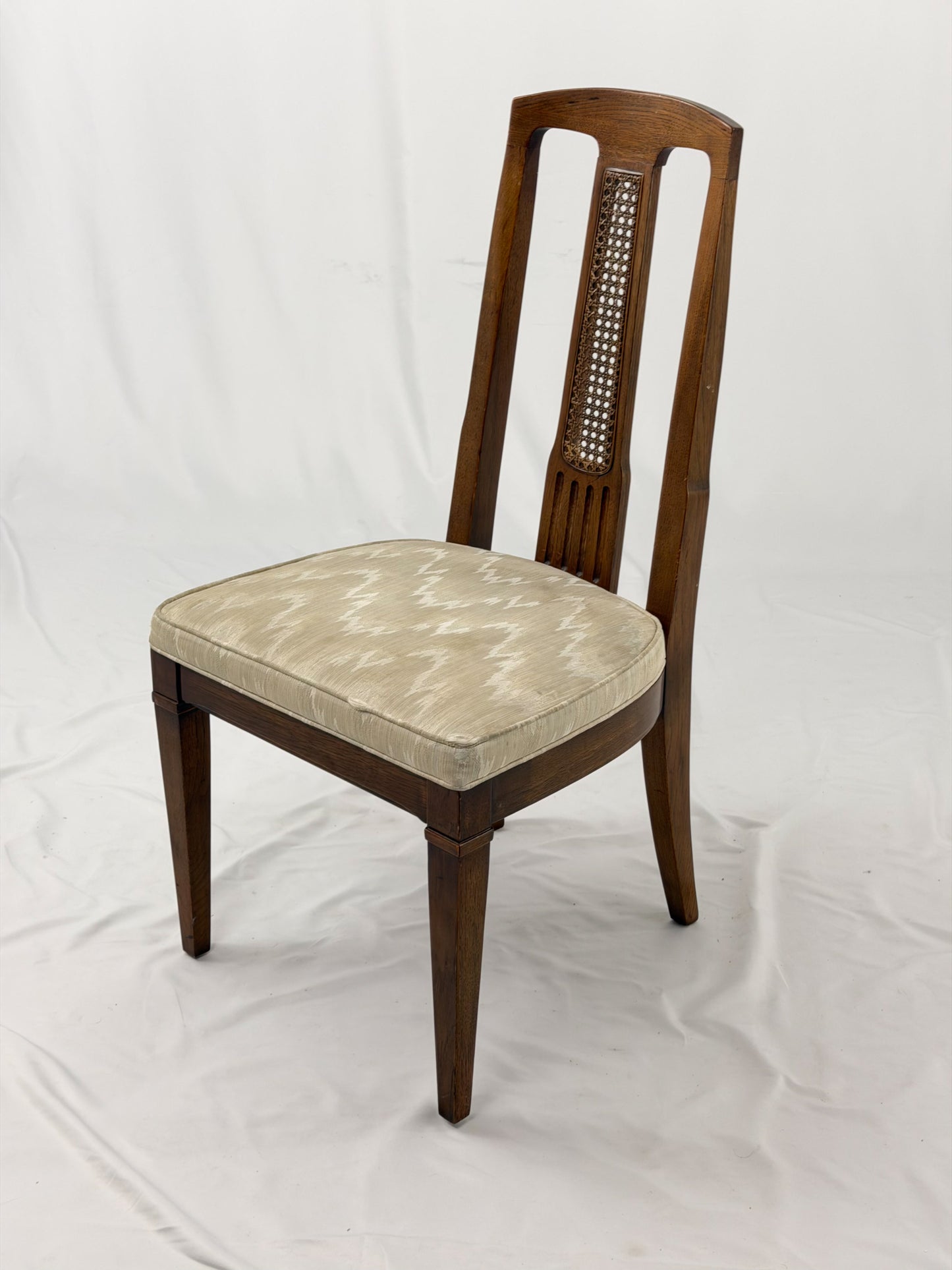 Wooden dining chair with a patterned cushion on a white background