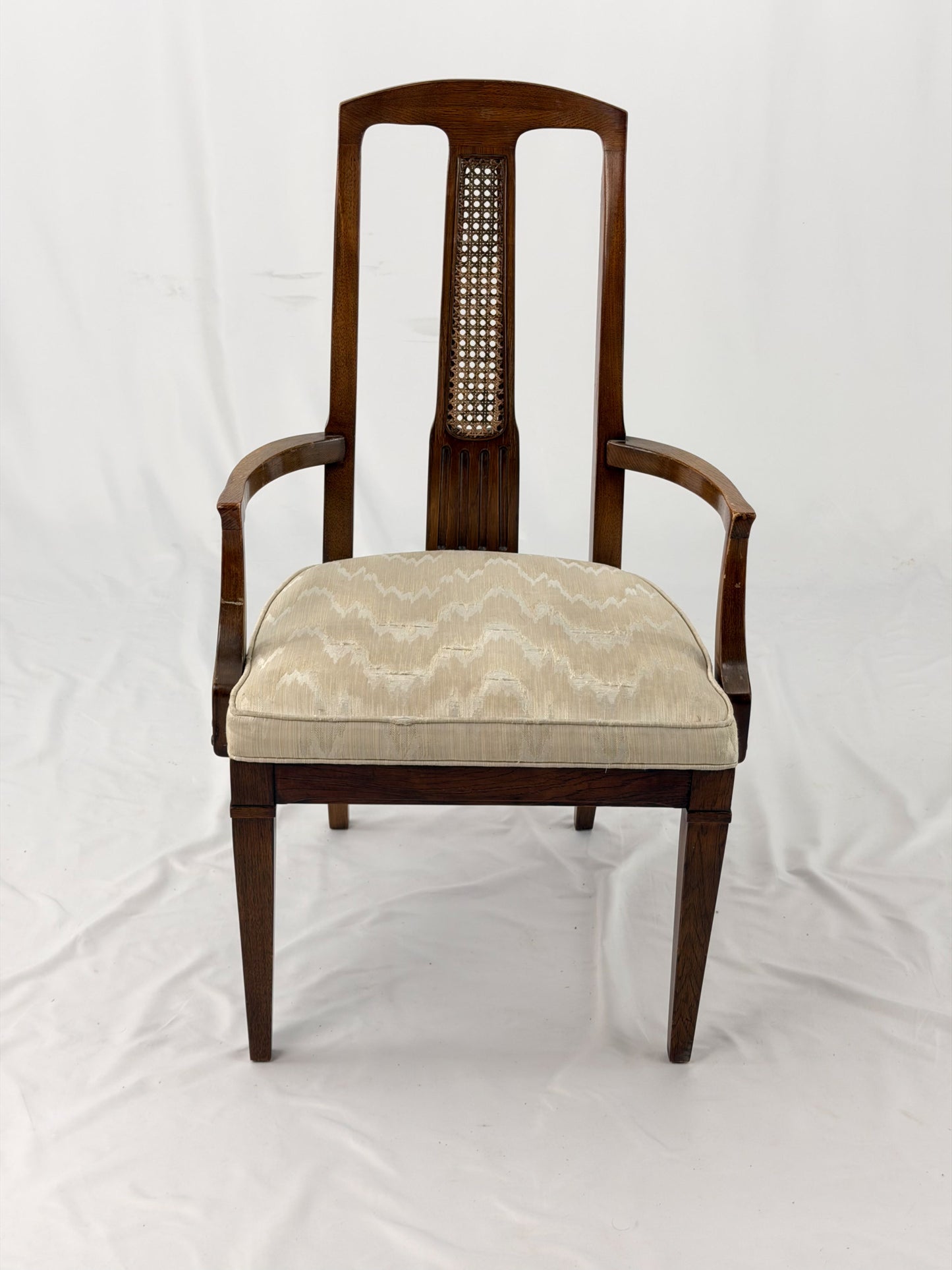 Wooden dining chair with a patterned cushion on a white background
